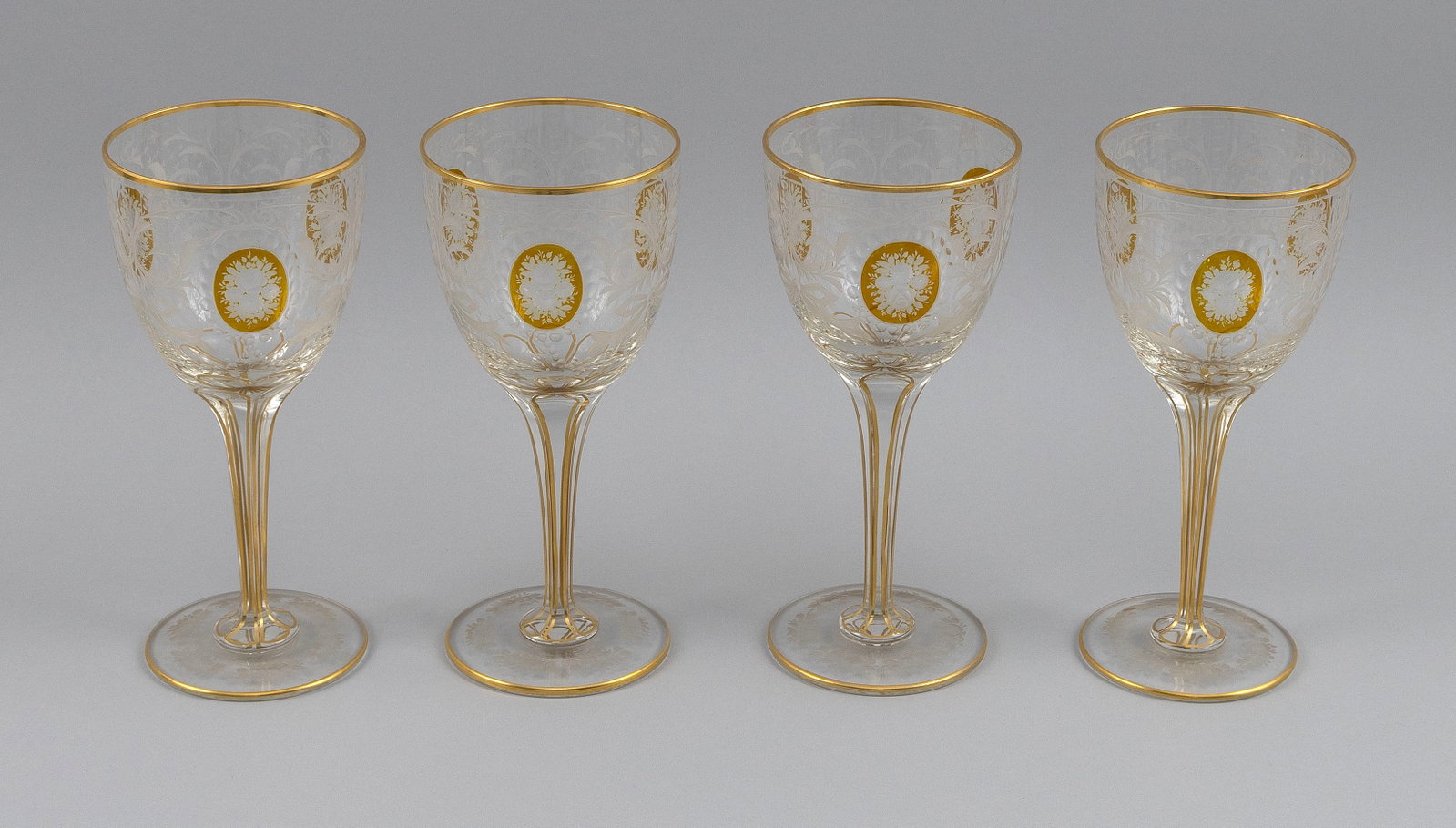 SET OF FOUR BOHEMIAM CUT GLASS WINEGLASSES Early 20th Century Heights 7.5".: SET OF FOUR BOHEMIAM CUT GLASS WINEGLASSES Early 20th Century Floral and ribbon decoration with gilt highlights. Heights 7.5".