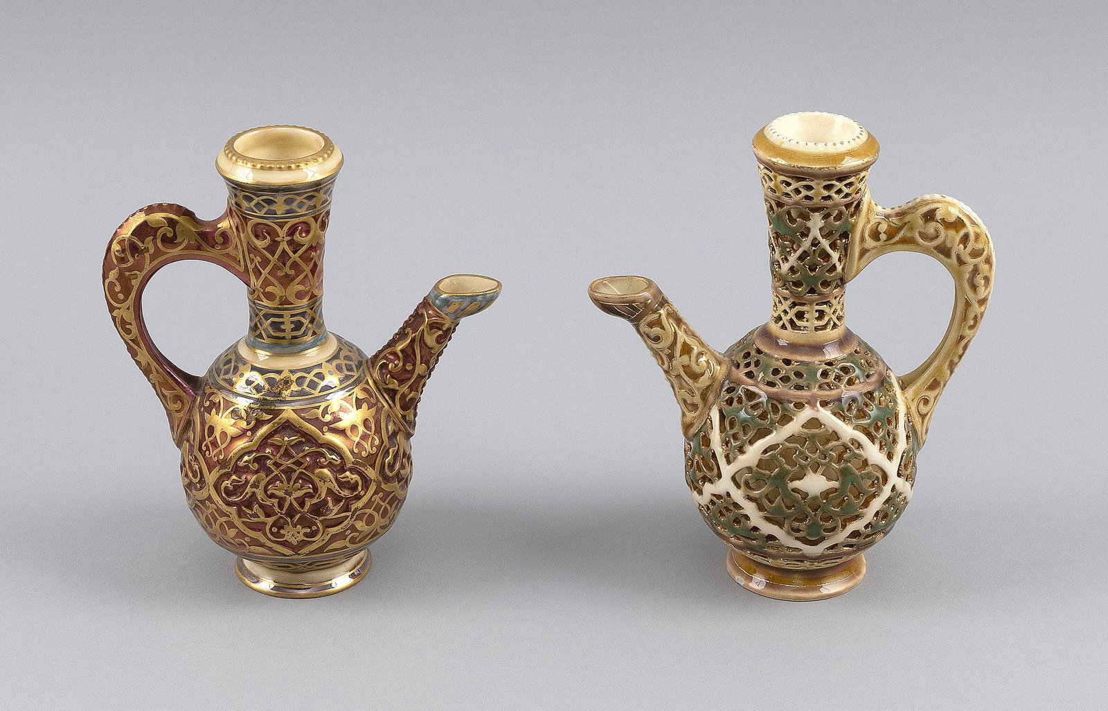 TWO MINIATURE ZSOLNAY PORCELAIN EWERS Hungary, Late 19th Century Heights 5.75".: TWO MINIATURE ZSOLNAY PORCELAIN EWERS Hungary, Late 19th Century Gilt and enamel decoration. Gilded mark on bases. Heights 5.75".