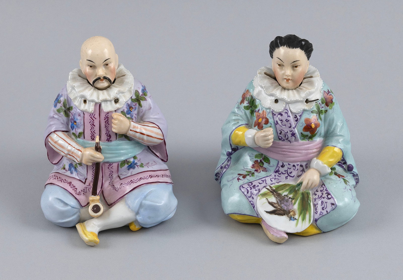 PAIR OF MEISSEN-STYLE PORCELAIN NODDER FIGURES 19th/20th Century Heights 4".: PAIR OF MEISSEN-STYLE PORCELAIN NODDER FIGURES 19th/20th Century Seated Chinese man and woman in famille rose-style robes with white ruffs, the man holding an opium pipe and the woman a fan. Unmarked.