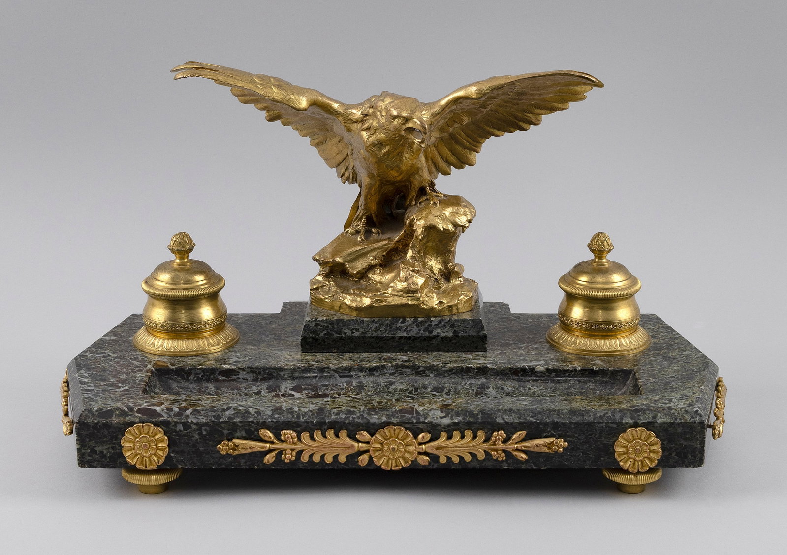 GILT-BRONZE AND MARBLE INKWELL Late 19th Century Height 9". Width 14.5". Depth 7.5".: GILT-BRONZE AND MARBLE INKWELL Late 19th Century Surmounted by a spread-wing eagle. Height 9". Width 14.5". Depth 7.5".
