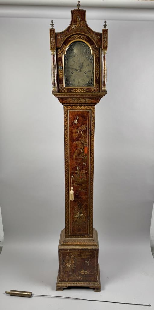 JAPANNED GRANDMOTHER CLOCK 19th Century Height 73.5". Width 12.75". Depth 9".: JAPANNED GRANDMOTHER CLOCK 19th Century Arched bonnet with three finials and brass-capped columns. Engraved brass face with Roman numeral dial. Brass medallion in lunette engraved "Tempus Fugit" (time