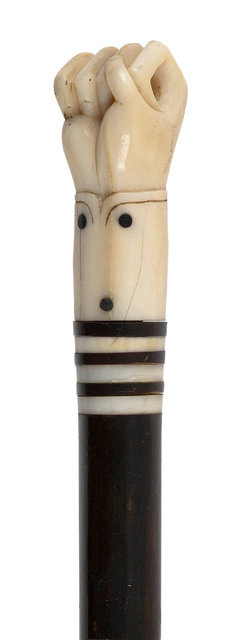 SCRIMSHAW LADY'S WALKING STICK America, Circa 1860 Length 32.5".: SCRIMSHAW LADY'S WALKING STICK America, Circa 1860 Whale ivory handle carved as a clenched right fist, the cuff inlaid with baleen "buttons". Ivory and baleen banded throat. Tapered exotic wood shaft 