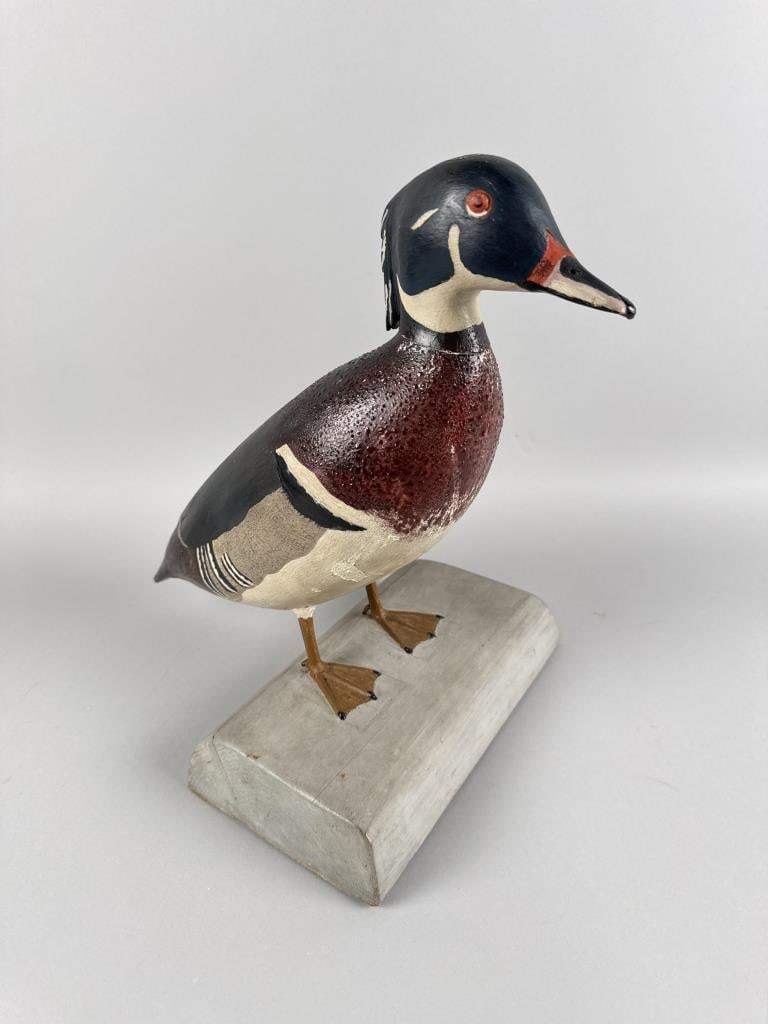 PRIMITIVE WOOD DUCK DRAKE CARVING Massachusetts, 20th Century Height 13.5".: PRIMITIVE WOOD DUCK DRAKE CARVING Massachusetts, 20th Century Standing on a gray-painted base. Stamped "Ford" on underside of base. Height 13.5".
