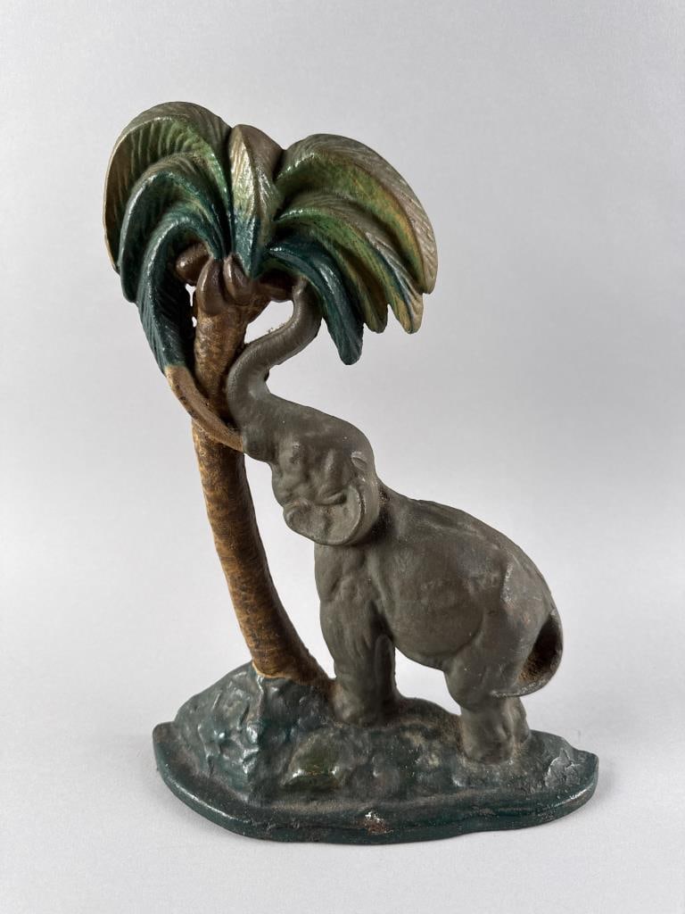 NATIONAL FOUNDRY POLYCHROMED CAST IRON ELEPHANT AND PALM TREE DOORSTOP Circa 1920 Height 13.5". (1 of 4)