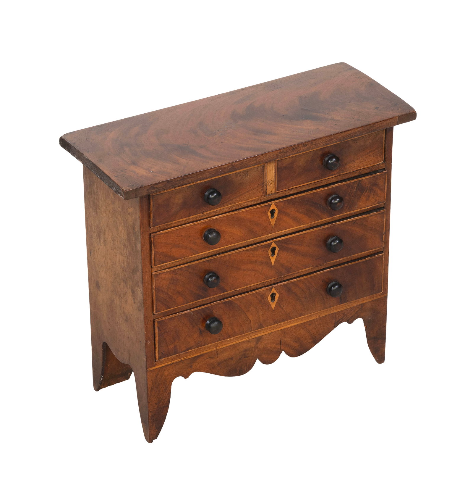 MINIATURE HEPPLEWHITE MAHOGANY AND MAHOGANY VENEER CHEST OF DRAWERS Early 19th Century Height: MINIATURE HEPPLEWHITE MAHOGANY AND MAHOGANY VENEER CHEST OF DRAWERS Early 19th Century Half drawers over three full-width drawers. Scrolled apron. High French splayed bracket feet. Height 13.75". Widt