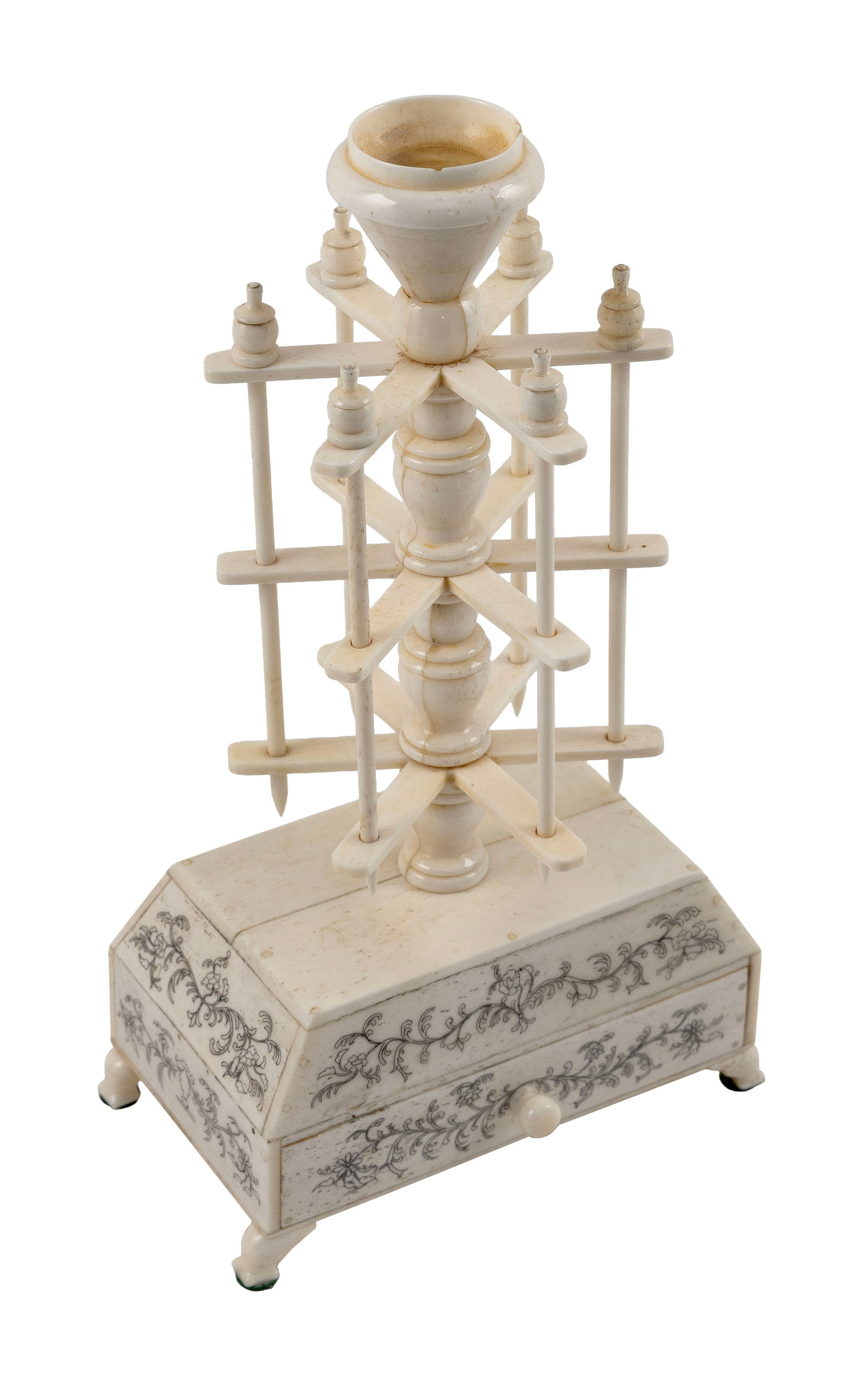SCRIMSHAW BONE AND IVORY THREAD WINDER ON STAND 19th Century Height 10.5". Width 5.75". Depth 4.5".: SCRIMSHAW BONE AND IVORY THREAD WINDER ON STAND 19th Century Winder topped with a yarn cup. One-drawer stand with shaped feet and engraved foliate vine decoration. J&P Coats label on interior. Height 
