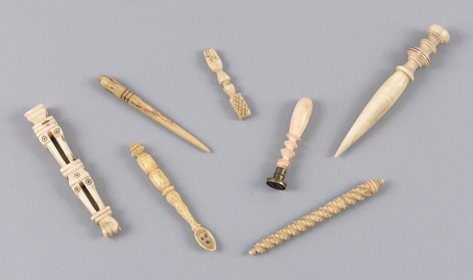 SEVEN SMALL CARVED WHALEBONE AND IVORY IMPLEMENTS 19th Century Lengths from 1.75" to 3.75".: SEVEN SMALL CARVED WHALEBONE AND IVORY IMPLEMENTS 19th Century 1) Turned whale ivory bodkin with red incised banding. 2) Whalebone bodkin with incised banding. 3) Rope-carved bone needle case with thr