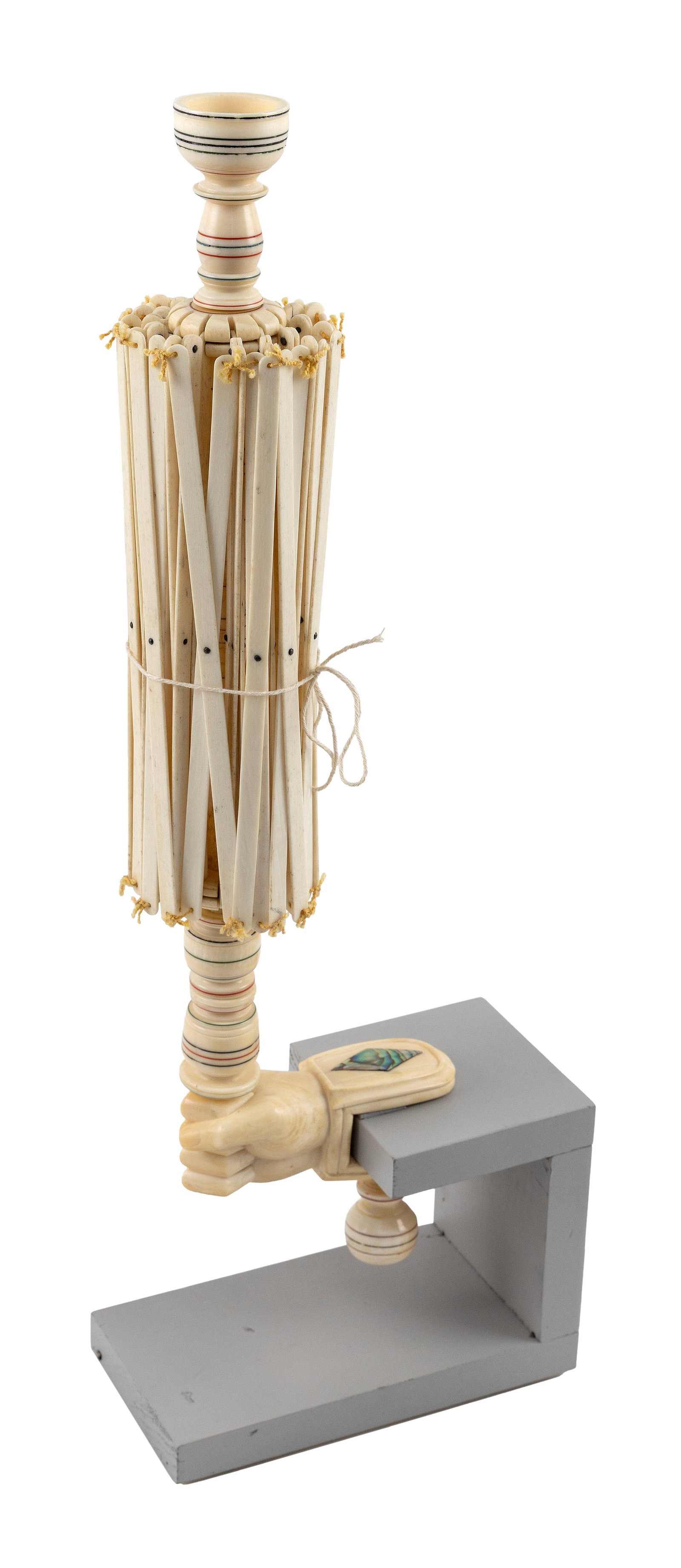 WHALEBONE AND WHALE IVORY SWIFT WITH CLENCHED FIST CLAMP Mid-19th Century Height 16.25". With: WHALEBONE AND WHALE IVORY SWIFT WITH CLENCHED FIST CLAMP Mid-19th Century Elaborately turned shaft with red and green sealing wax banding. Shaft topped with a diminutive yarn cup. Clenched fist clamp 