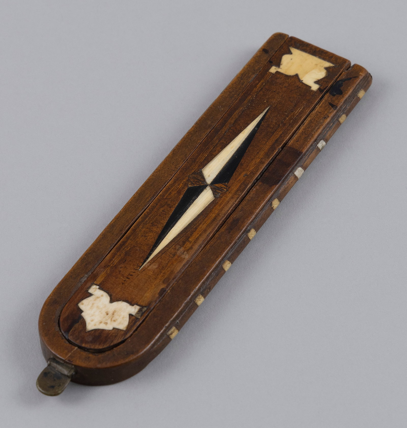 INLAID WOODEN NUTMEG GRATER 19th Century Length 6.875".: INLAID WOODEN NUTMEG GRATER 19th Century Sliding lid, which covers the metal grater, inlaid with contrasting and marine mammal ivory geometric designs. Pique inlay along edges. Length 6.875".