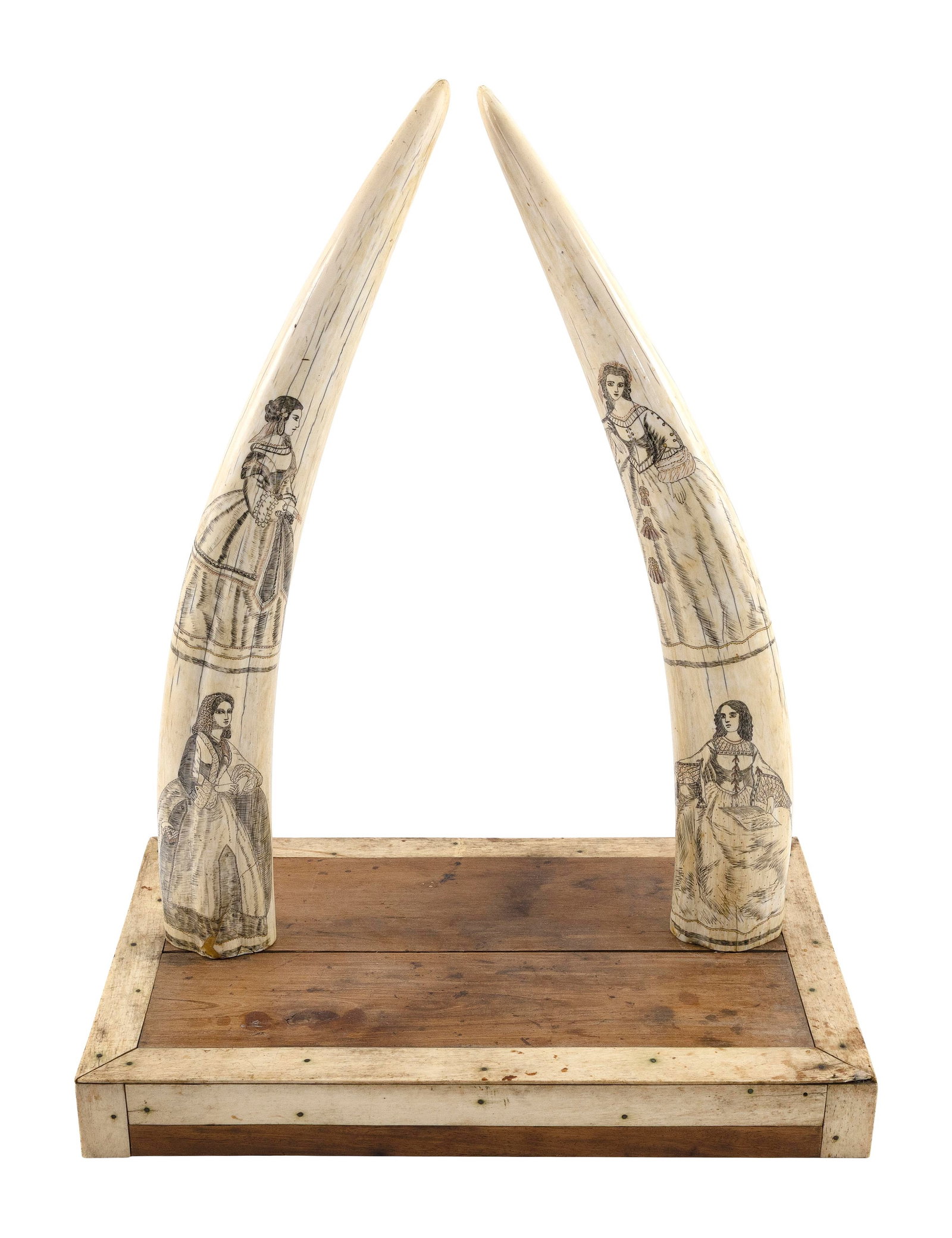 PAIR OF MOUNTED POLYCHROME SCRIMSHAW WALRUS TUSKS 19th Century Tusk lengths approx. 18.5". Base: PAIR OF MOUNTED POLYCHROME SCRIMSHAW WALRUS TUSKS 19th Century Both tusks with two portraits of women in elaborate dress, likely sourced from Godey's Lady's Book. Red highlights. Mounted on a wood and