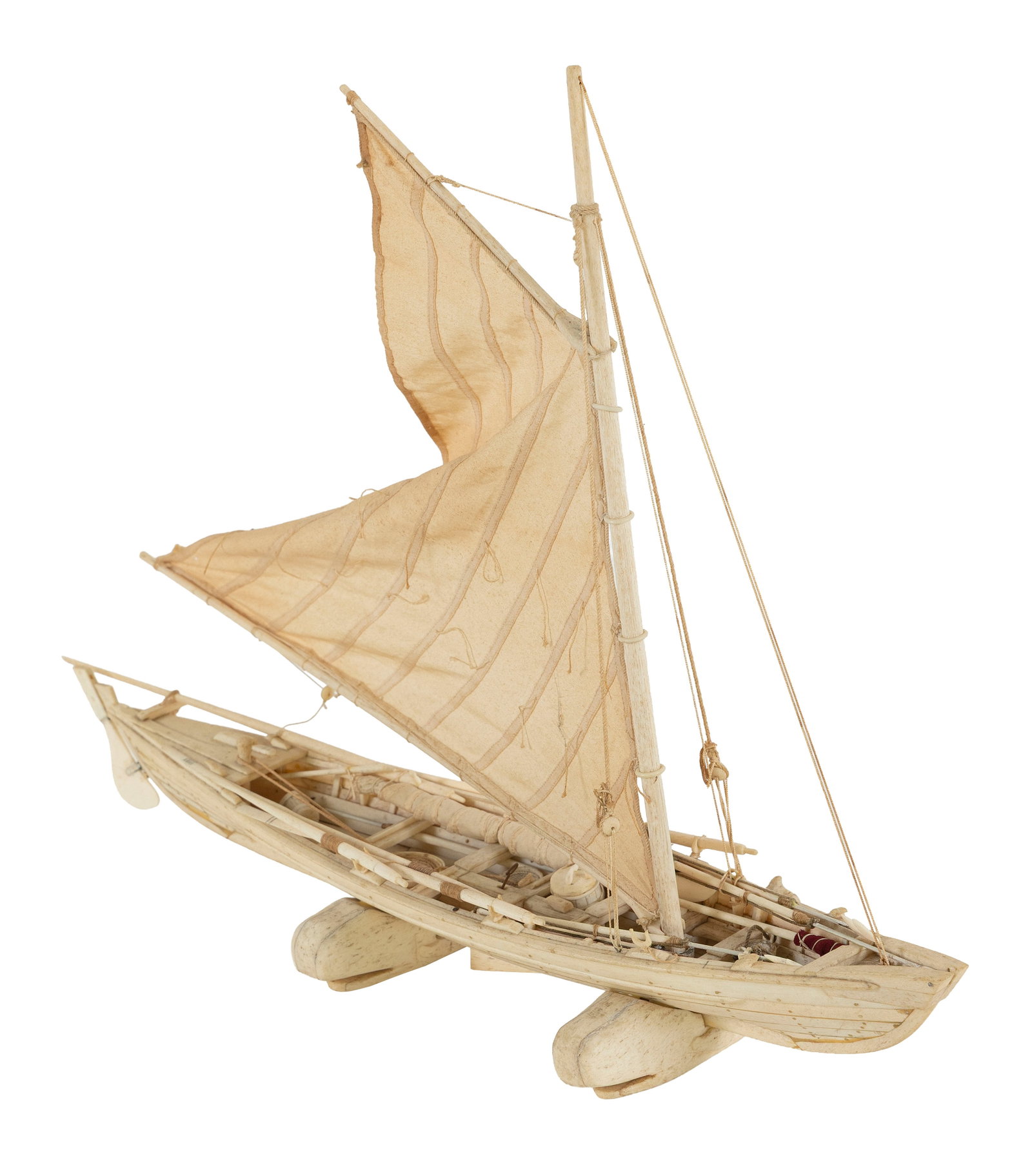 CARVED BONE MODEL OF A WHALEBOAT Late 19th/Early 20th Century Height on cradle 16". Length 21".: CARVED BONE MODEL OF A WHALEBOAT Late 19th/Early 20th Century Plank-on-frame construction. Complete with sails, spars, harpoons, line buckets, oars, etc. and rigged with a sail. Displayed on two carve