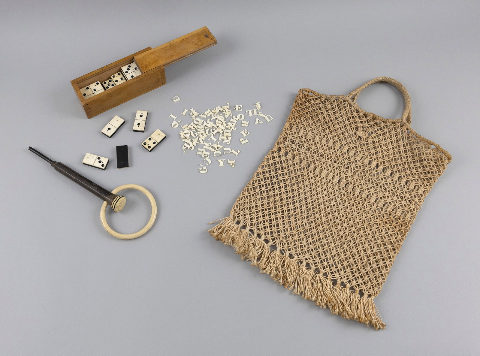 ODD LOT OF MARITIME ITEMS Early 20th Century Box height 2". Length 7". Width 2.75".: ODD LOT OF MARITIME ITEMS Early 20th Century Includes a macrame bag, a boxed set of 28 carved dominoes, a set of carved whalebone letters, and a carved hardwood shaft with a bone ring. Box height 2". 