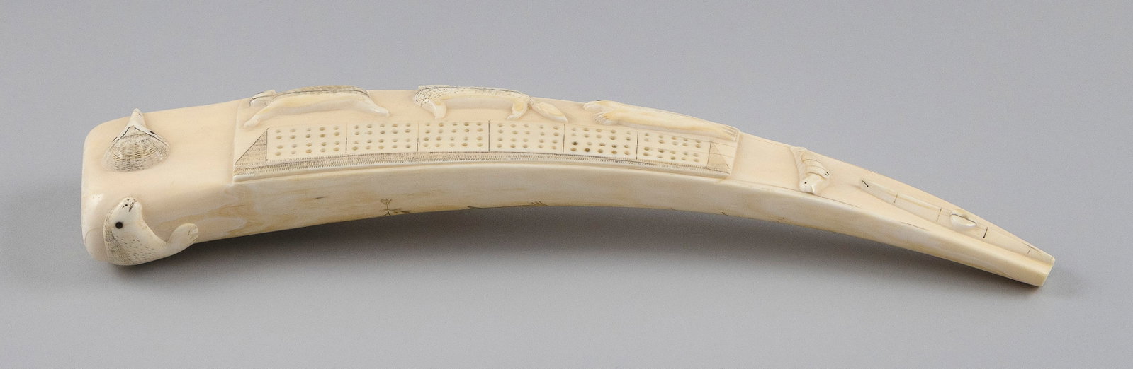 ESKIMO RELIEF-CARVED AND ENGRAVED WALRUS TUSK CRIBBAGE BOARD Early 20th Century Length 15". (1 of 4)