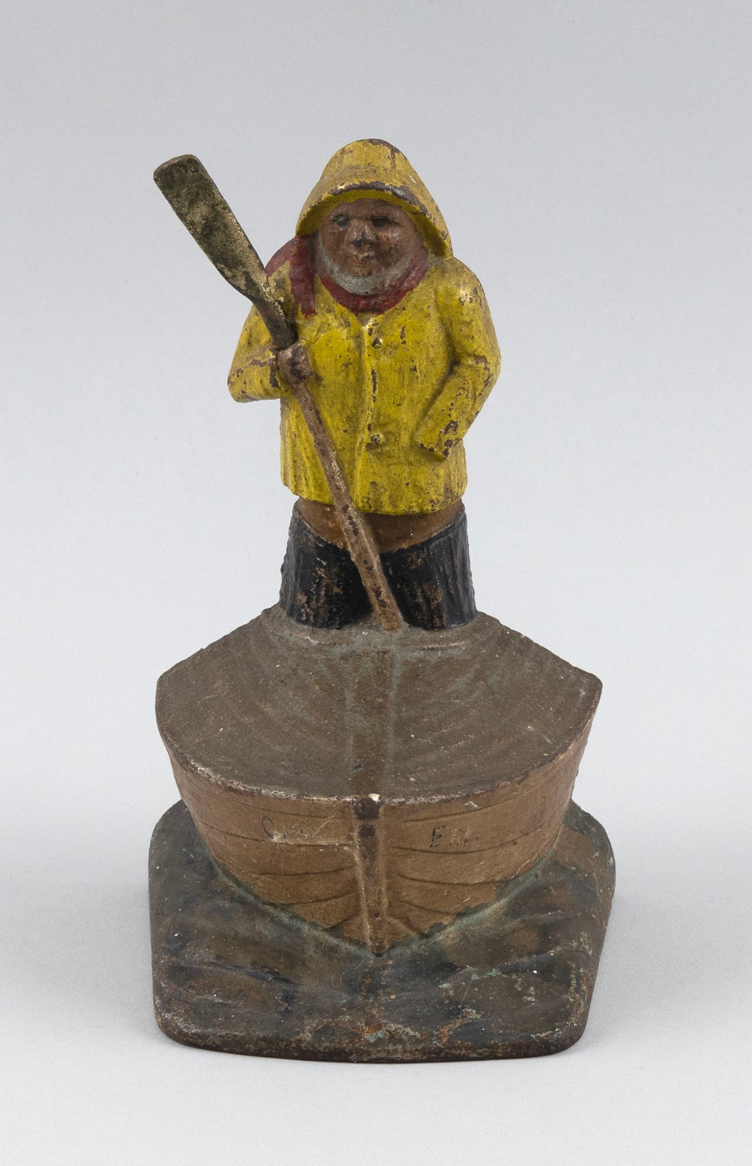 POLYCHROMED CAST IRON SAILOR MAN IN BOAT DOORSTOP Early 20th Century Height 7".: POLYCHROMED CAST IRON SAILOR MAN IN BOAT DOORSTOP Early 20th Century Formed as an "Old Salt" with oar, standing toward the bow of a boat. Height 7".