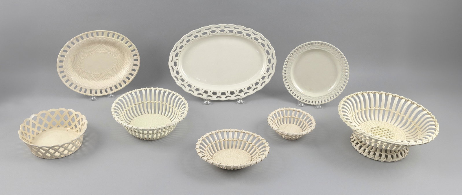 EIGHT PIECES OF CREAMWARE 19th and 20th Century Diameters from 5.5" to 10". Lengths from 10.25" to: EIGHT PIECES OF CREAMWARE 19th and 20th Century Two platters, one plate and five baskets, all with reticulated edges. Diameters from 5.5" to 10". Lengths from 10.25" to 13.5".
