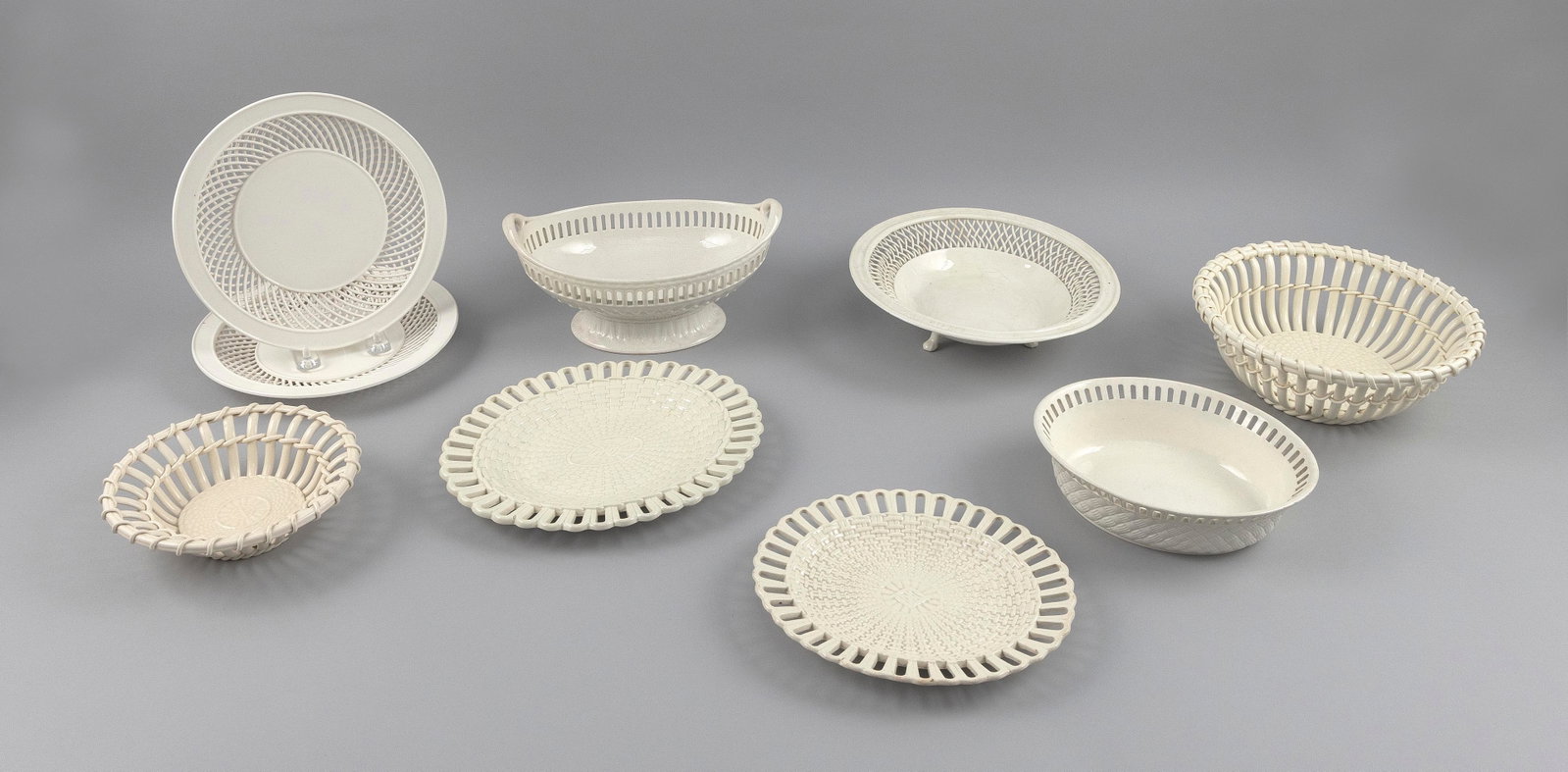 NINE PIECES OF CREAMWARE 19th and 20th Century Diameters from 6.5" to 9.25". Lengths from 8" to: NINE PIECES OF CREAMWARE 19th and 20th Century Two small platters, three plates and four baskets, all with reticulated edges. Diameters from 6.5" to 9.25". Lengths from 8" to 9.25".