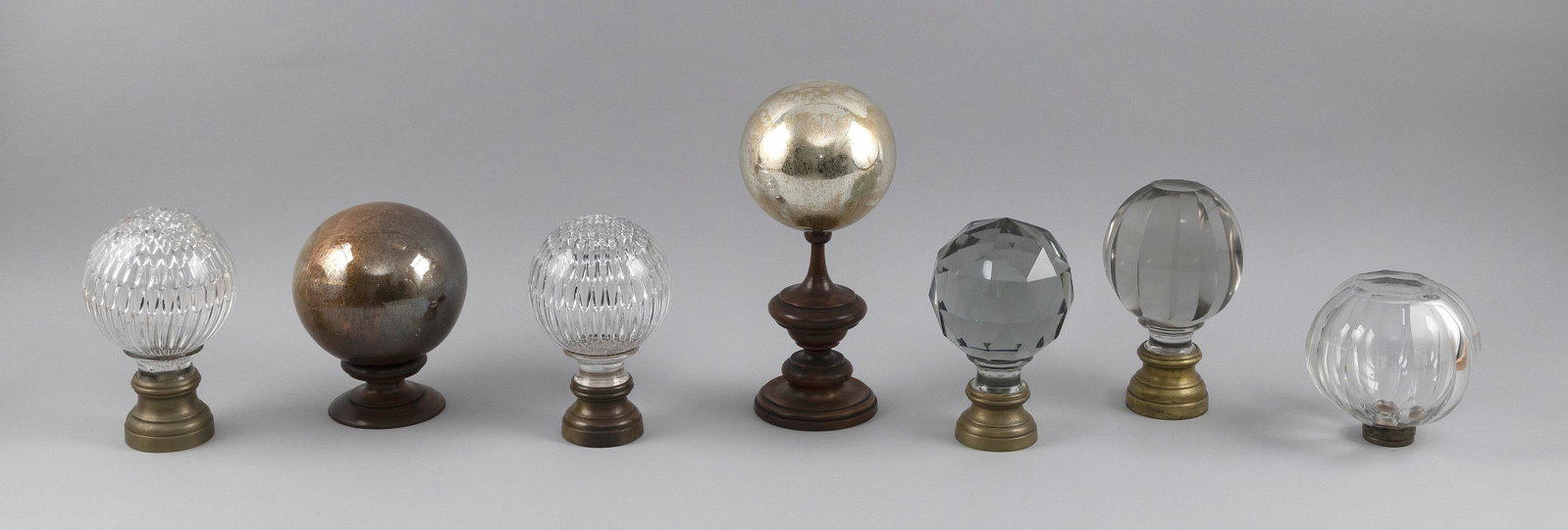 COLLECTION OF SEVEN GLASS NEWEL POST BALL FINIALS Late 19th to 20th Century Heights from 5" to: COLLECTION OF SEVEN GLASS NEWEL POST BALL FINIALS Late 19th to 20th Century Five clear glass, one signed Baccarat, and two mercury glass. Baccarat example lacking base. Heights from 5" to 10.5".