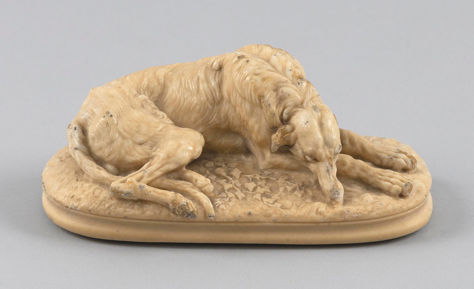 AFTER PAUL GAYARD (Early to Mid-20th Century,), A sleeping deerhound, Height 2.5". Length 6". Width: AFTER PAUL GAYARD Early to Mid-20th Century A sleeping deerhound, a composite stone carving. Handwritten on underside "Bought in Paris Petite Flea Market 1973 MP" and "Moppet". Height 2.5". Length 6".