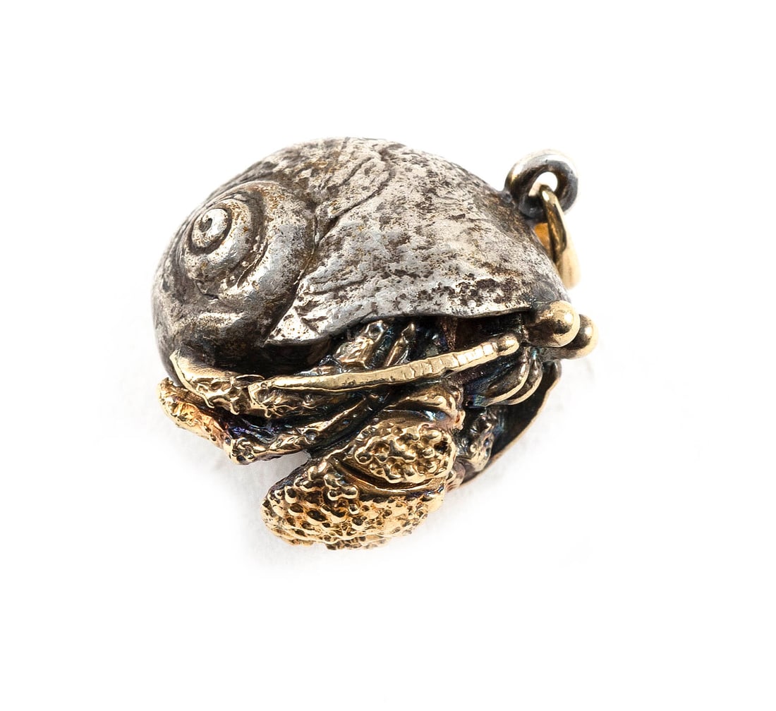 14KT YELLOW GOLD AND STERLING SILVER HERMIT CRAB PENDANT Approx. 7.3 total dwt.: 14KT YELLOW GOLD AND STERLING SILVER HERMIT CRAB PENDANT Sterling silver shell and gold hermit crab and bail. Stamped. Approx. 12.0 x 19.0 x 19.0mm. Approx. 7.3 total dwt.