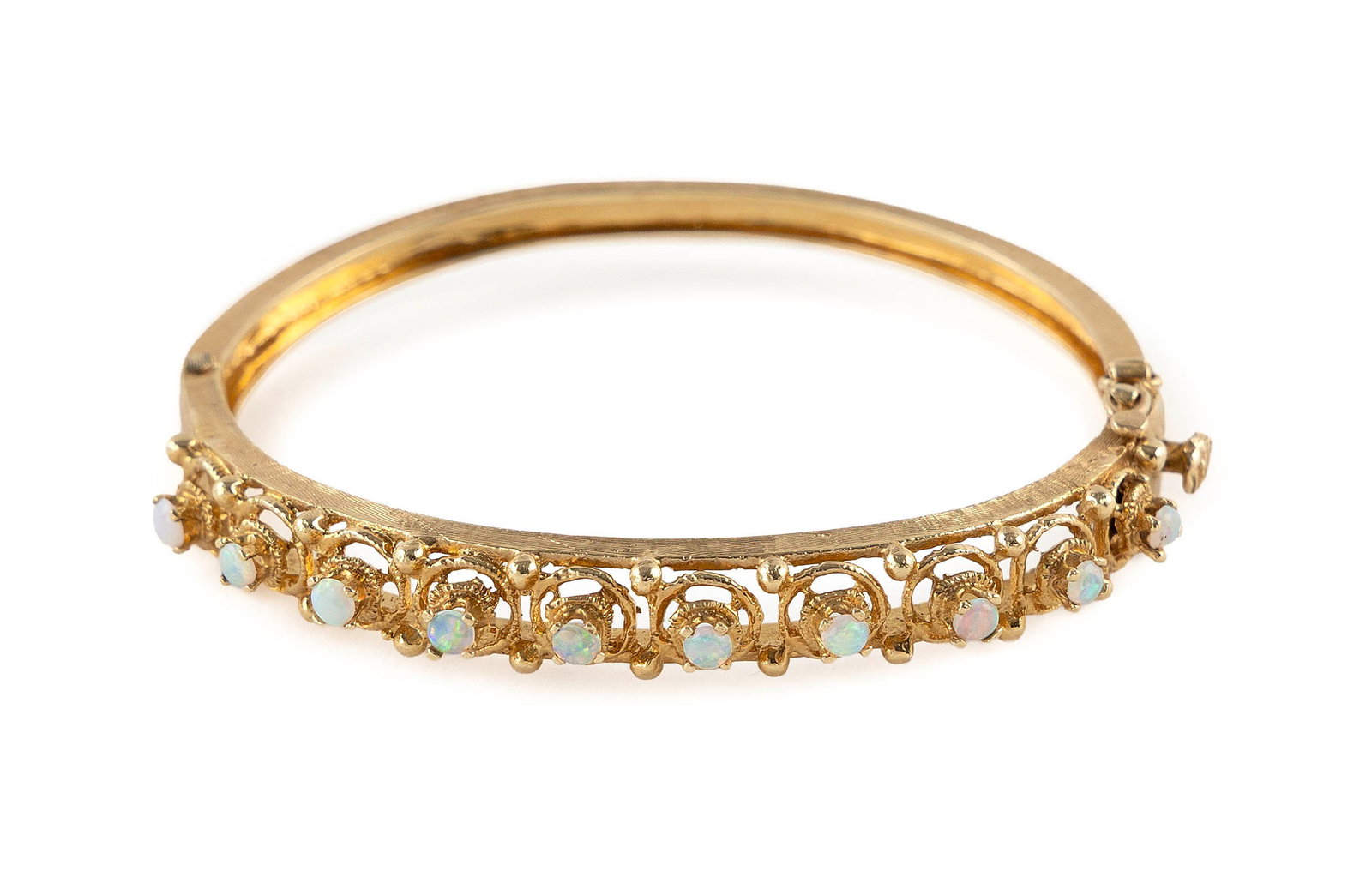 14KT YELLOW GOLD AND OPAL BANGLE BRACELET Approx. 10.8 total dwt.: 14KT YELLOW GOLD AND OPAL BANGLE BRACELET Ten approx. 3.0mm round cabochon opals. Florentine finish. Box clasp with fold-over safety. Stamped. Width tapers from approx. 7.0 to 4.0mm. Length 6". Approx