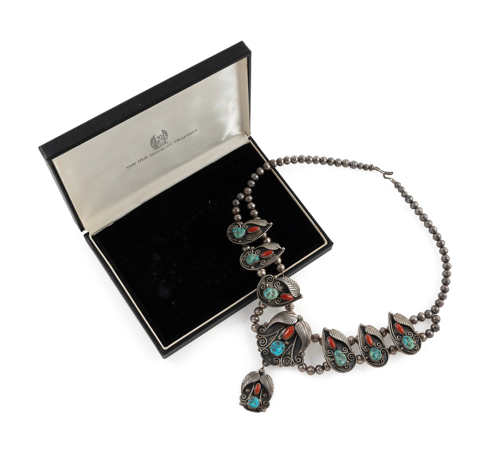 NAVAJO SILVER, TURQUOISE AND CORAL SQUASH BLOSSOM NECKLACE Mid-20th Cerntury Approx. 144.7 grams: NAVAJO SILVER, TURQUOISE AND CORAL SQUASH BLOSSOM NECKLACE Mid-20th Cerntury Six blossoms each with one turquoise and one coral stone with silver feather decorations. Matching two-piece Naja. Necklace