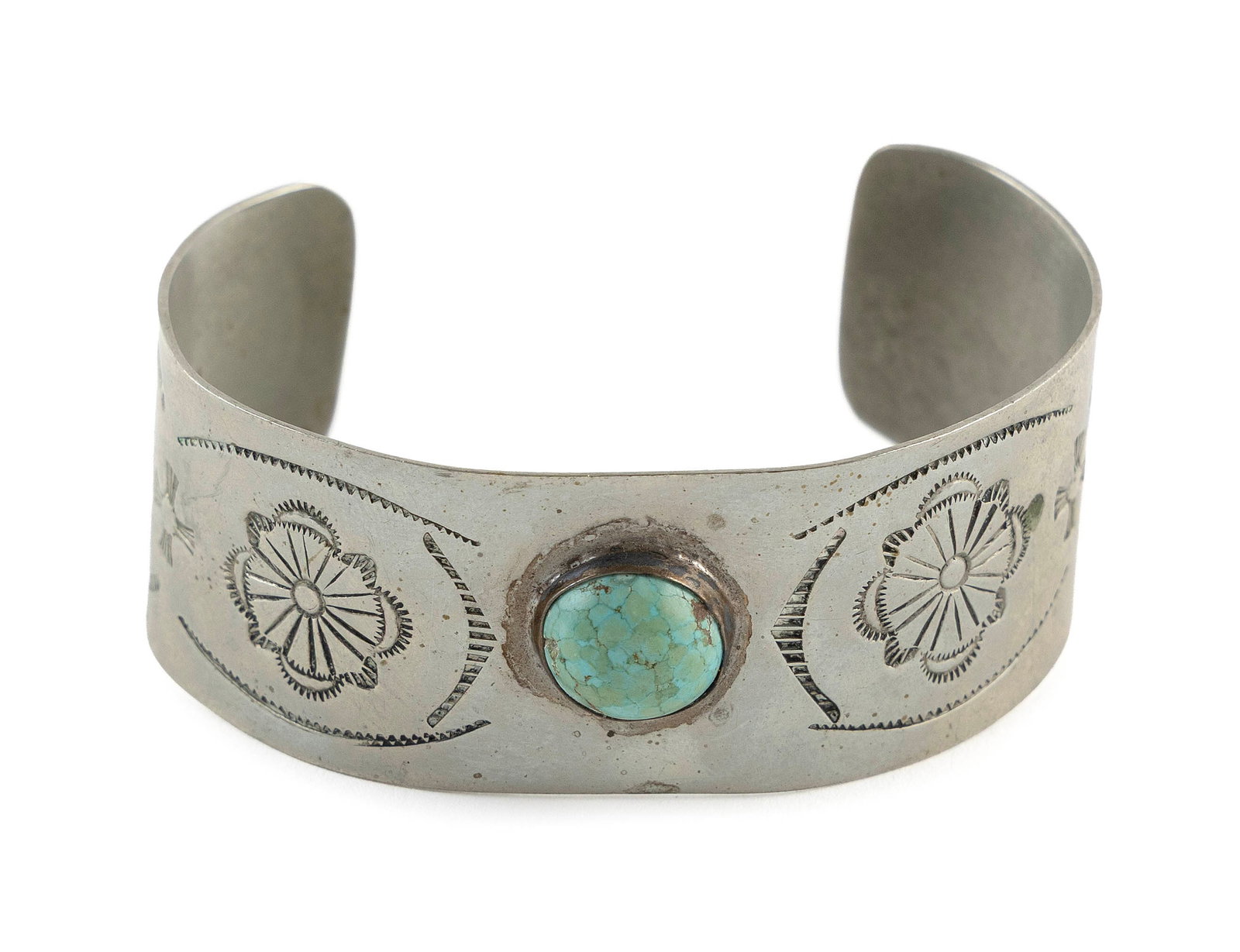 NAVAJO SILVER AND TURQUOISE CUFF BRACELET Mid-20th Century: NAVAJO SILVER AND TURQUOISE CUFF BRACELET Mid-20th Century Stamped designs and a round bezel-set turquoise. No marks, but likely not sterling. Opening 2.5" x 1.875".