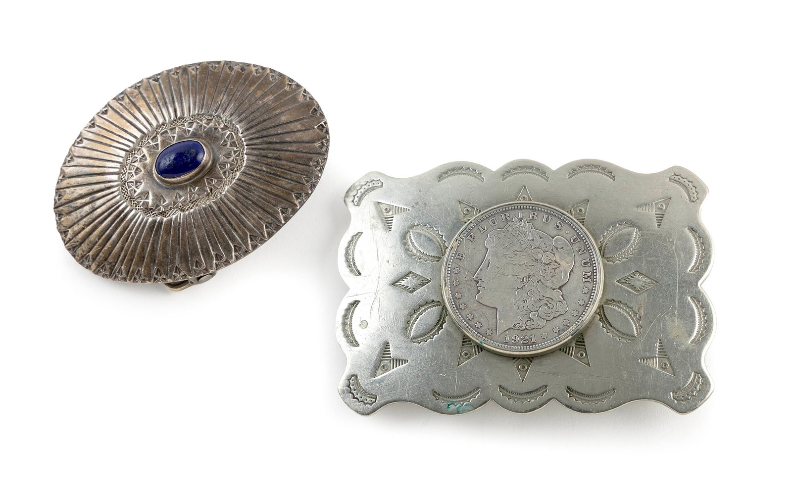 TWO NATIVE AMERICAN SILVER BELT BUCKLES Mid- to Late 20th Century: TWO NATIVE AMERICAN SILVER BELT BUCKLES Mid- to Late 20th Century 1) Rectangular form with inset 1921 Liberty silver dollar and stamped designs. Approx. 2.5" x 3.5". Marked "Solid Nickel Silver". Appr