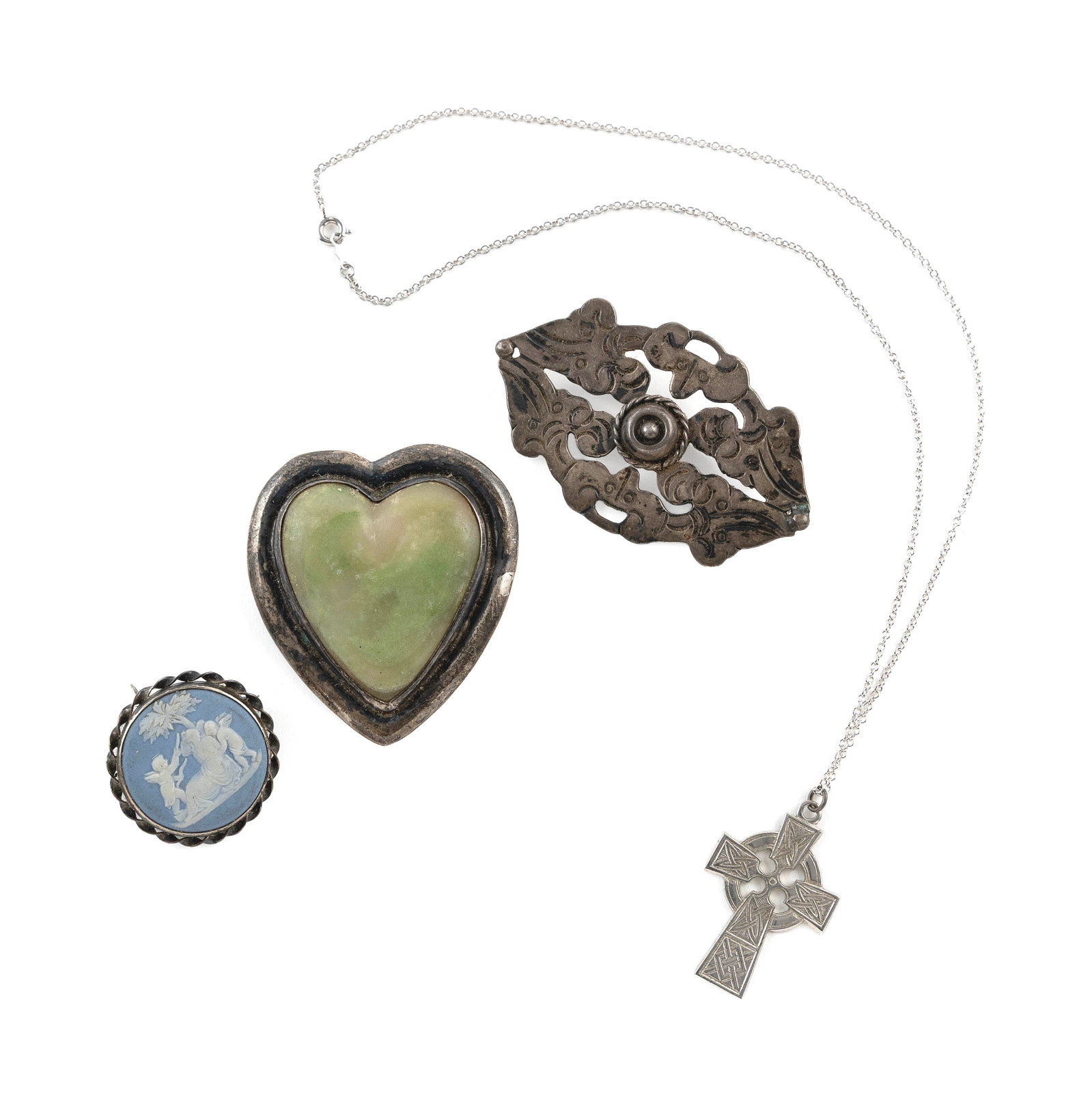 FOUR PIECES OF STERLING SILVER PINS AND PENDANTS Approx. 41.2 total dwt.: FOUR PIECES OF STERLING SILVER PINS AND PENDANTS 1) Jade heart pin. Approx. 48.0 x 54.0mm. 2) Wedgwood pin/pendant. Diameter approx. 30.0mm. 3) Mexican pin. Approx. 39.0 x 64.0mm. 4) Celtic Cross pend