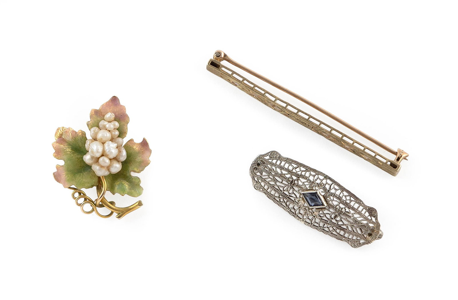 THREE VINTAGE 10KT GOLD PINS Approx. 4.6 total dwt.: THREE VINTAGE 10KT GOLD PINS 1) White gold filigree pin with one approx. 4.0 x 6.0mm diamond shaped simulated sapphire. Approx. 13.0 x 34.0mm. 2) Yellow gold bar pin with pierced design. Approx. 2.0 x
