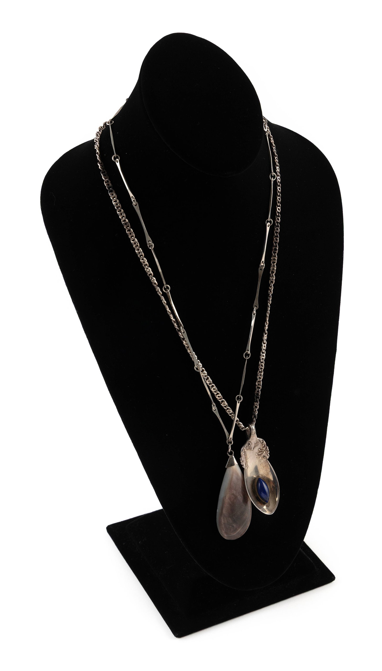 TWO STERLING SILVER PENDANTS ON CHAINS Approx. 62.1 total dwt.: TWO STERLING SILVER PENDANTS ON CHAINS 1) Approx. 28.0 x 63.0mm mother-of-pearl pendant. Bar link style chain with spring ring clasp, length 22". 2) Approx. 26.0 x 65.0mm vintage spoon pendant with an