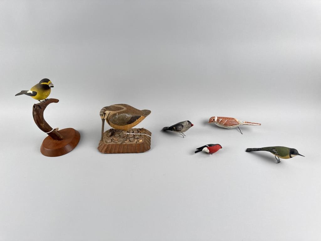 SIX BIRD CARVINGS 20th Century: SIX BIRD CARVINGS 20th Century 1) Woodcock with glass eyes, mounted on a wood base with naturalistic ground cover. Signed and dated "KM Orang 1988". Height 5.5". Length 6.75". Width 5". 2) Grosbeak wi