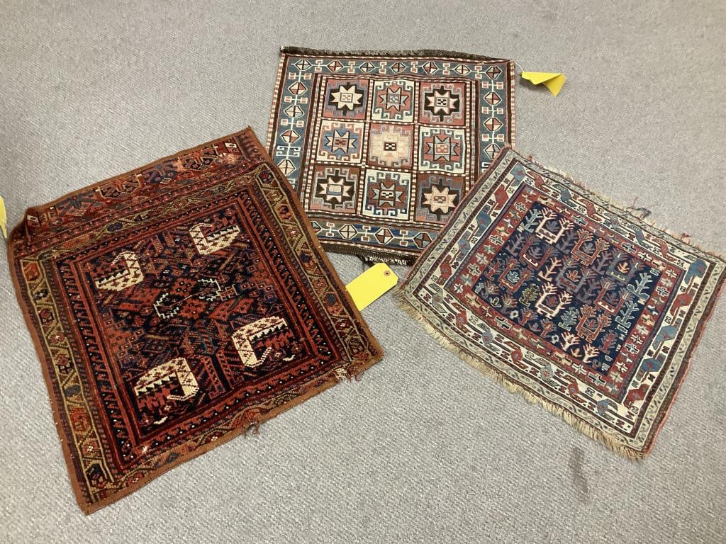 THREE BAGFACES: FROM 1'7" X 1'9" TO 1'10" X 2'1" 20th Century: THREE BAGFACES: FROM 1'7" X 1'9" TO 1'10" X 2'1" 20th Century 1) Southwest Persian with red and ivory elements on a dark blue field. 2) Soumac with grid design in faded shades of red, blue, pink and b