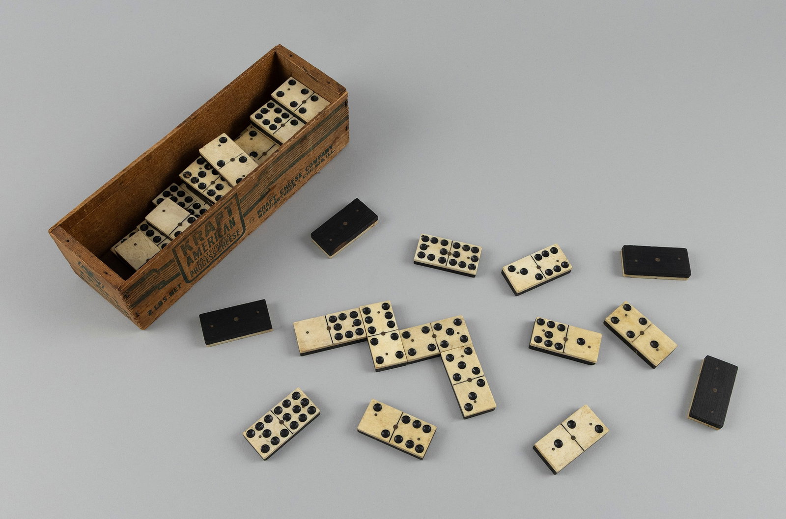 BOXED SET OF FIFTY-ONE WHALEBONE AND EBONY DOMINOES Early 20th Century Box height 2.75". Length 9". (1 of 1)