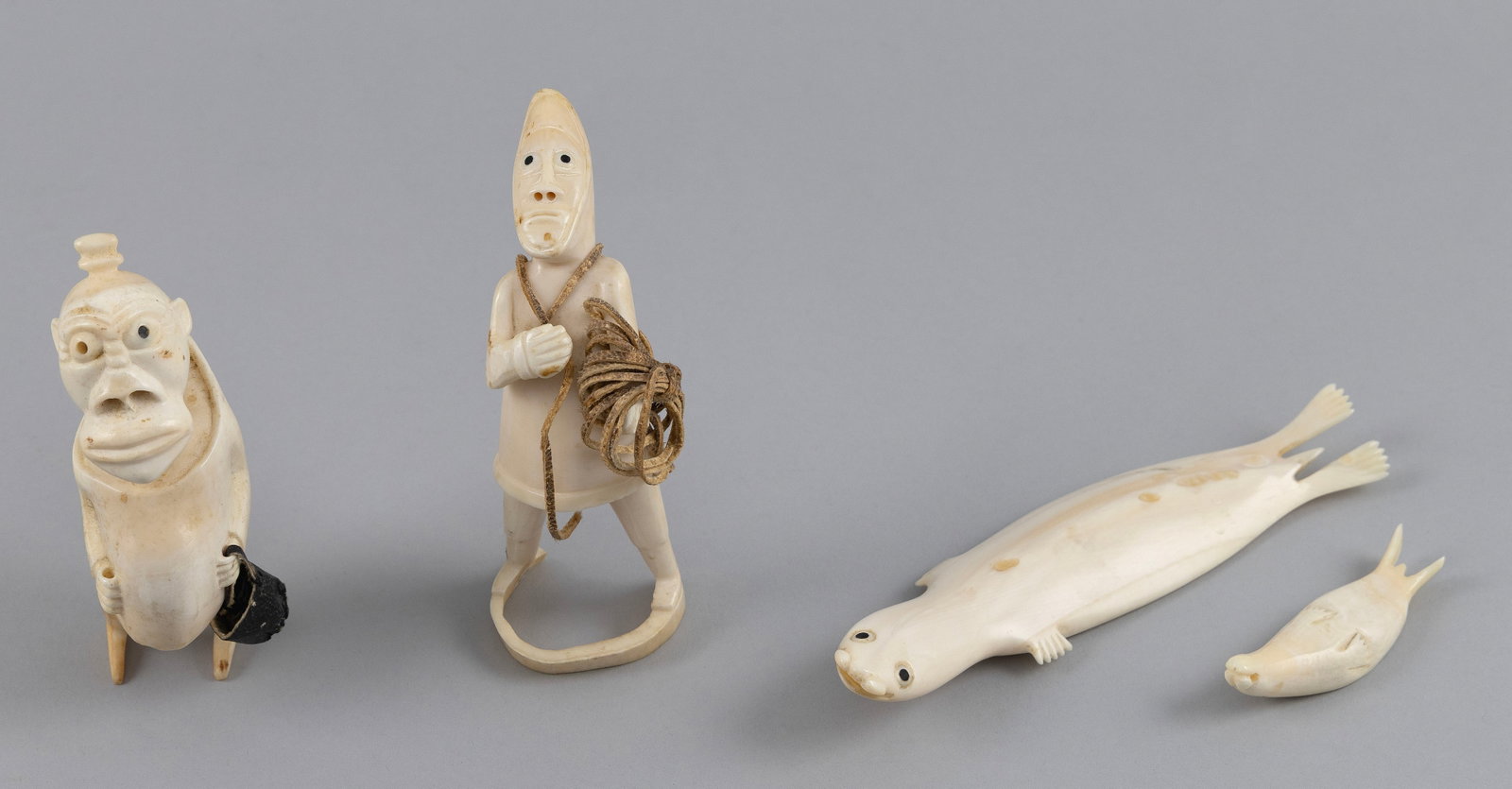 FOUR INUIT CARVED IVORY TUPILAKS Greenland, 20th Century Lengths from 2.75" to 6.5". (1 of 5)