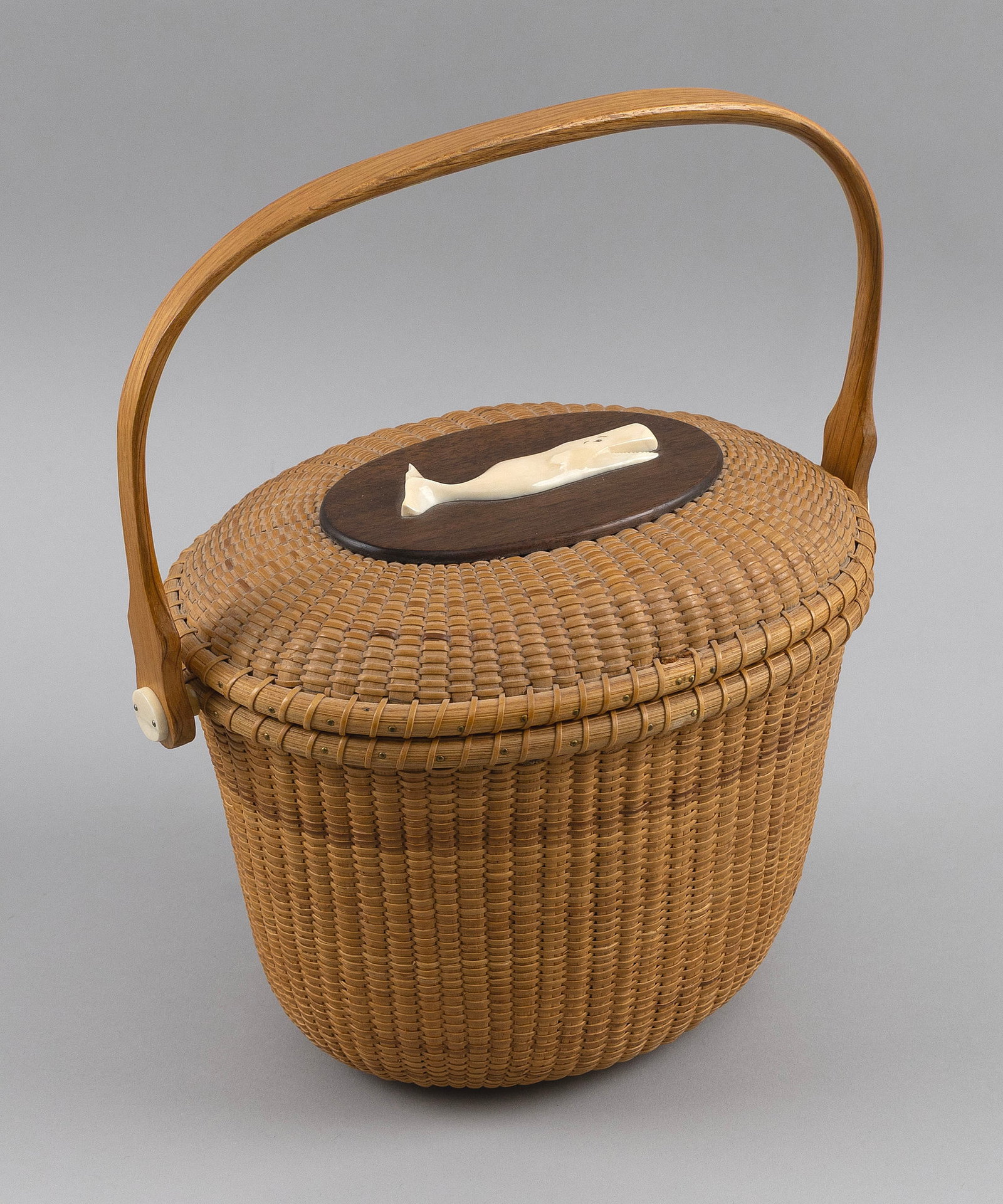 WHALER'S CRAFTS NANTUCKET FRIENDSHIP BASKET PURSE Nantucket, Massachusetts, dated 1967 Height 6.25".: WHALER'S CRAFTS NANTUCKET FRIENDSHIP BASKET PURSE Nantucket, Massachusetts, dated 1967 Lid mounted with a carved whale. Button at base of interior marked "Whaler's Crafts 1967" around an image of a