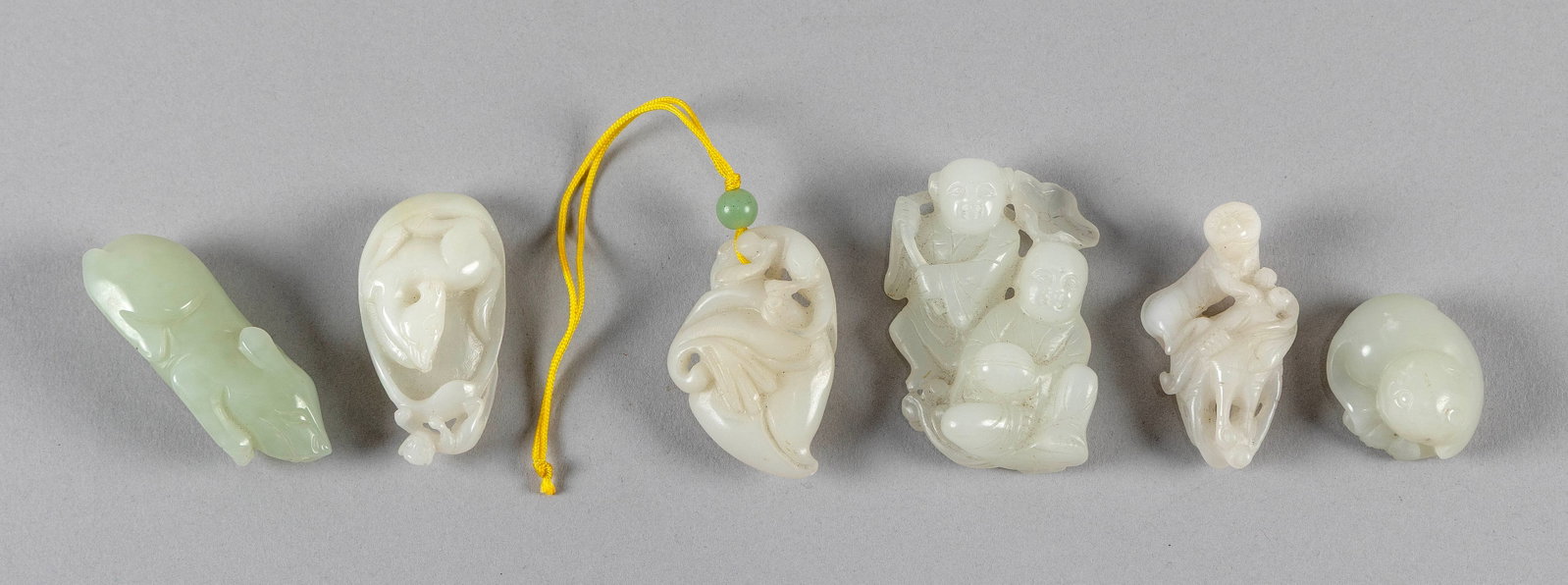 SIX SMALL WHITE JADE CARVINGS: SIX SMALL WHITE JADE CARVINGS 1) Two boys, one standing with lotus staff and the other seated with a bowl. Height 2.5". 2) Recumbent pig. Length 2.5". 3) Recumbent horse in a gourd, with a small monke