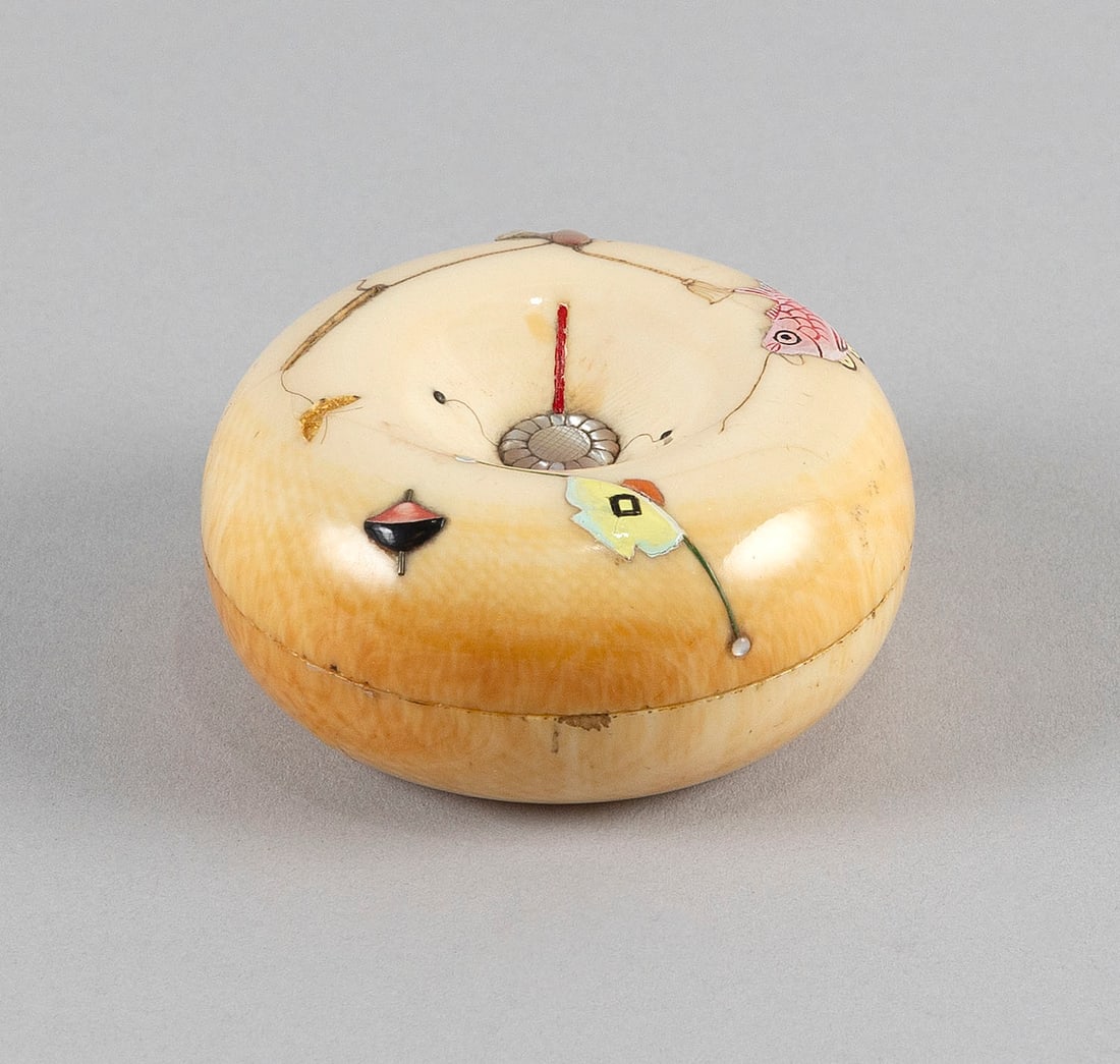 JAPANESE CARVED IVORY AND MOTHER-OF-PEARL COVERED BOX BY HIROMITSU Late 19th Century Diameter 3".: Y Y JAPANESE CARVED IVORY AND MOTHER-OF-PEARL COVERED BOX BY HIROMITSU Late 19th Century Inlaid and painted decoration of various toys. Signed on a mother-of-pearl plaque on base. Diameter 3". **This 