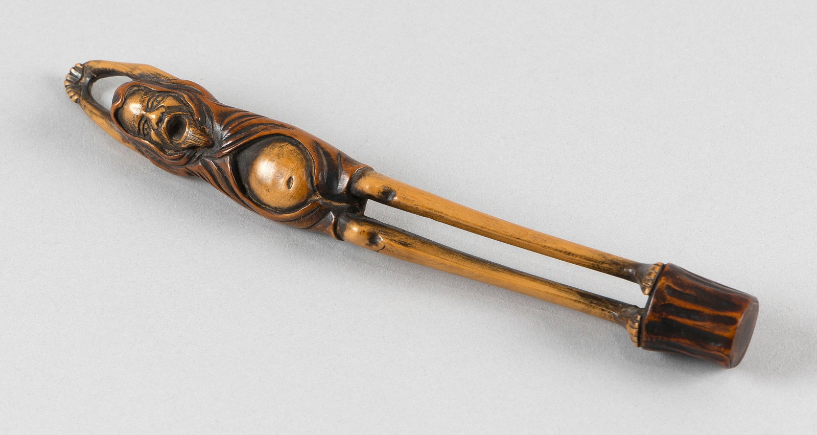 JAPANESE BOXWOOD PIPE CASE 19th Century Length 8".: JAPANESE BOXWOOD PIPE CASE 19th Century Carved as Daruma with long bare legs and an exposed belly, stretching his hands over his head and opening his mouth in a deep yawn. Unsigned. Length 8".