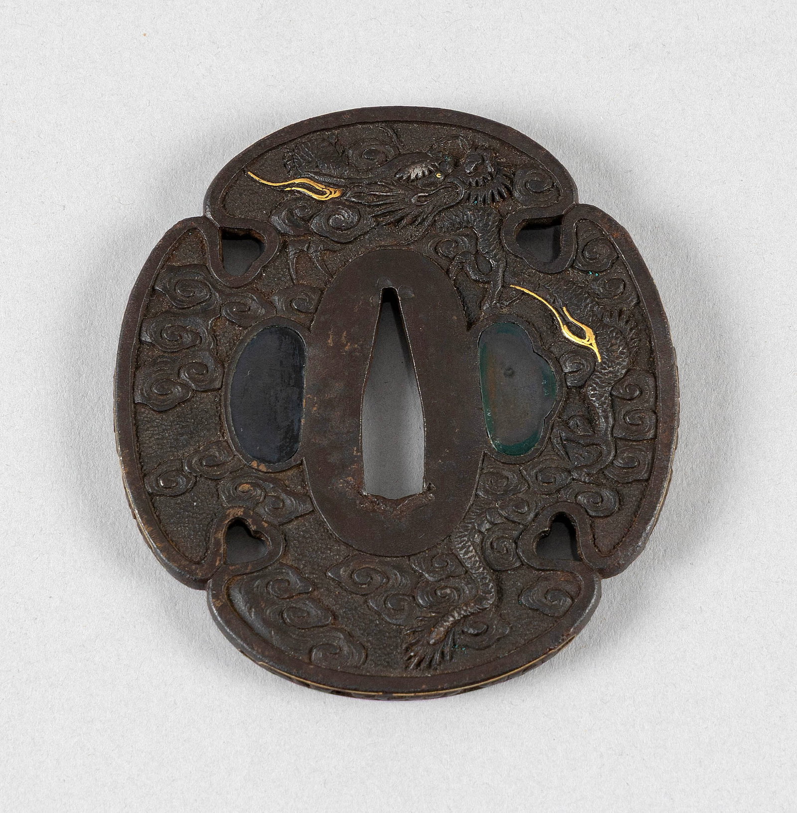 JAPANESE IRON MOKKO GATA TSUBA Edo Period Length 3".: JAPANESE IRON MOKKO GATA TSUBA Edo Period Intricate cloud and dragon decoration against a cloud-filled ground. Gold inlay on both sides. Length 3".