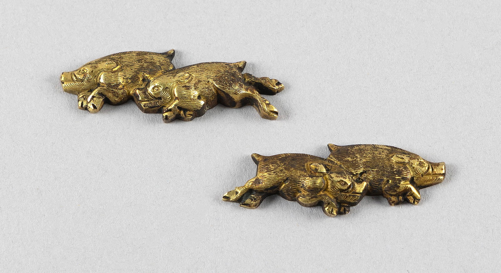 PAIR OF JAPANESE GILT BRONZE MENUKI Meiji Period Lengths 1.5".: PAIR OF JAPANESE GILT BRONZE MENUKI Meiji Period Formed as running boar. In original box from Bernheimer's Antique Art, Brattle Street, Cambridge, Massachusetts. Lengths 1.5". Provenance: Bernheimer's