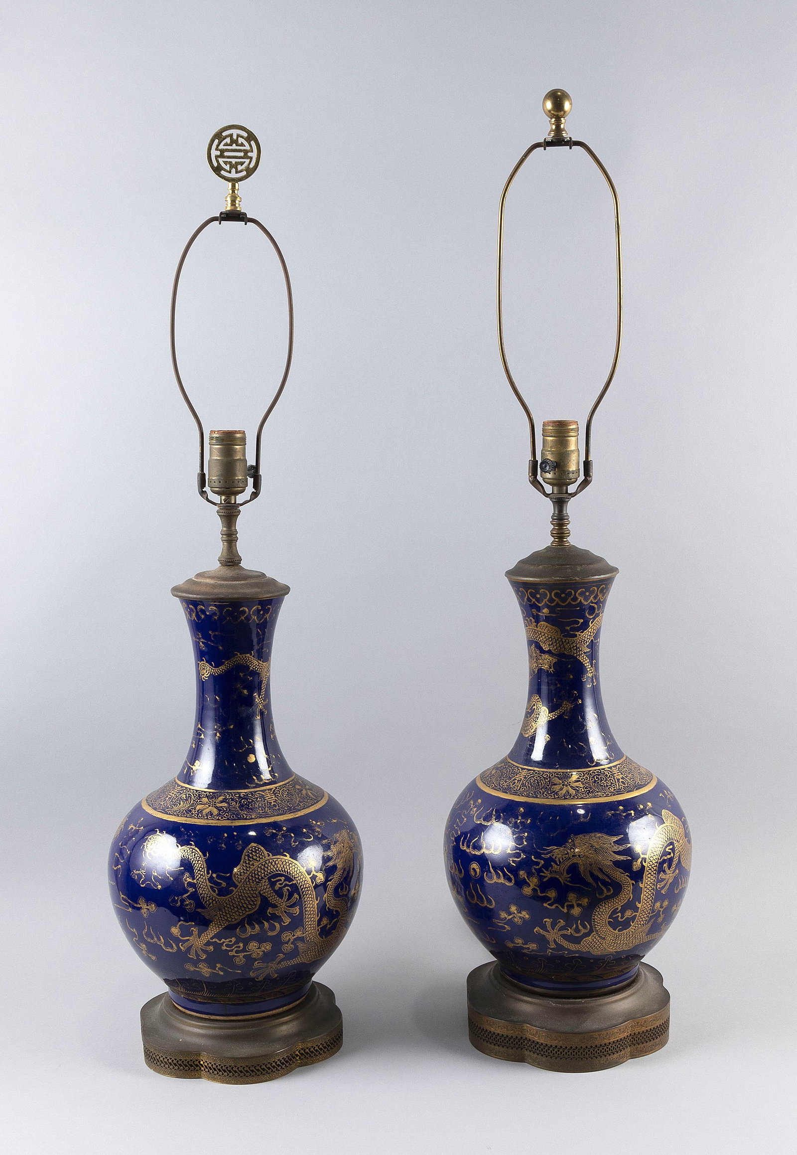 PAIR OF CHINESE GILT ON COBALT BLUE PORCELAIN BOTTLE VASES 19th Century Vase heights 15". Total: PAIR OF CHINESE GILT ON COBALT BLUE PORCELAIN BOTTLE VASES 19th Century Decoration of five-clawed dragons chasing a fiery pearl and banding about the shoulder. Mounted as table lamps on metal bases. V