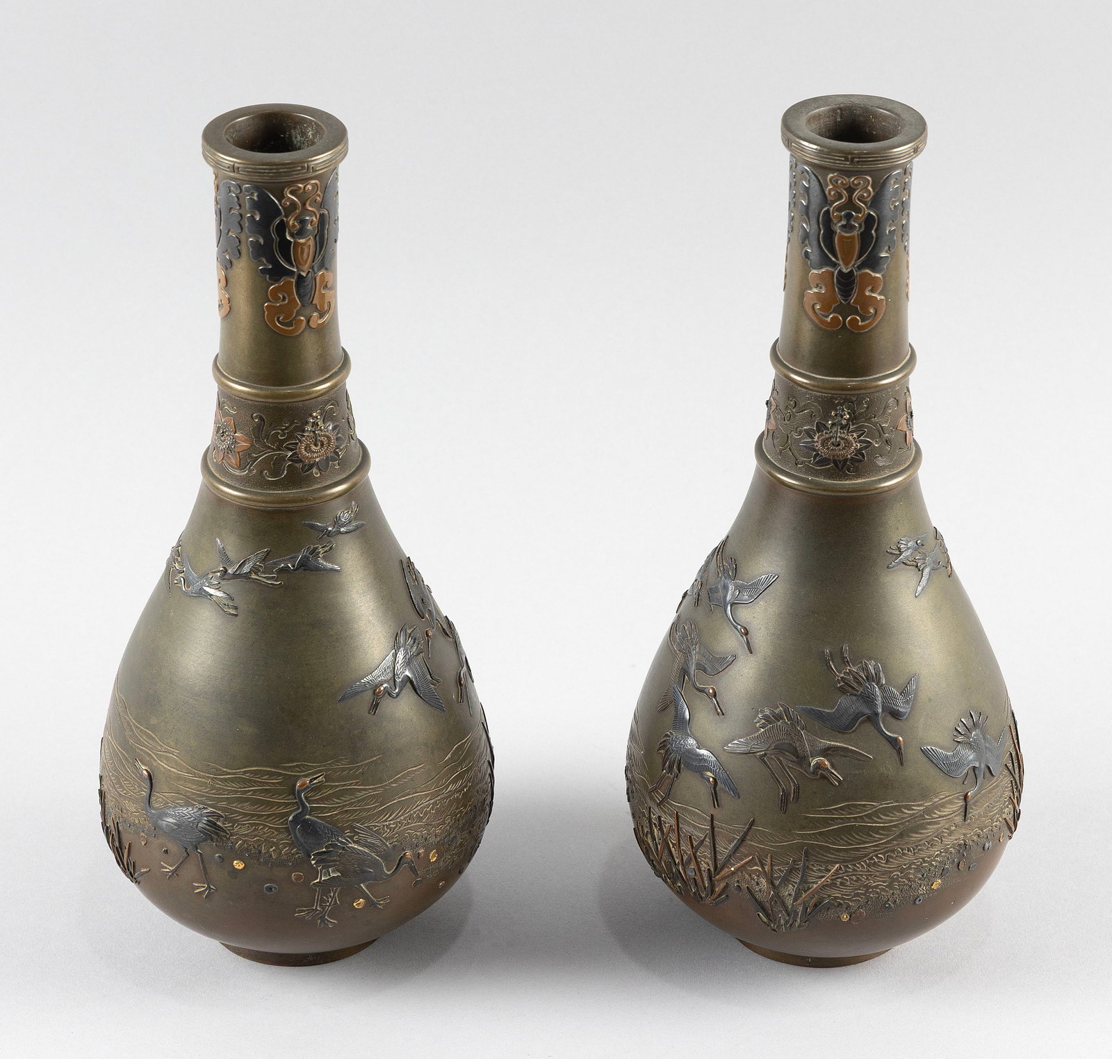 PAIR OF JAPANESE BRONZE AND MIXED METAL VASES Meiji Period Heights 11".: PAIR OF JAPANESE BRONZE AND MIXED METAL VASES Meiji Period Pear form with banded floral decoration and butterflies on the neck, and silver, gold and copper decoration of cranes flying over a marsh lan