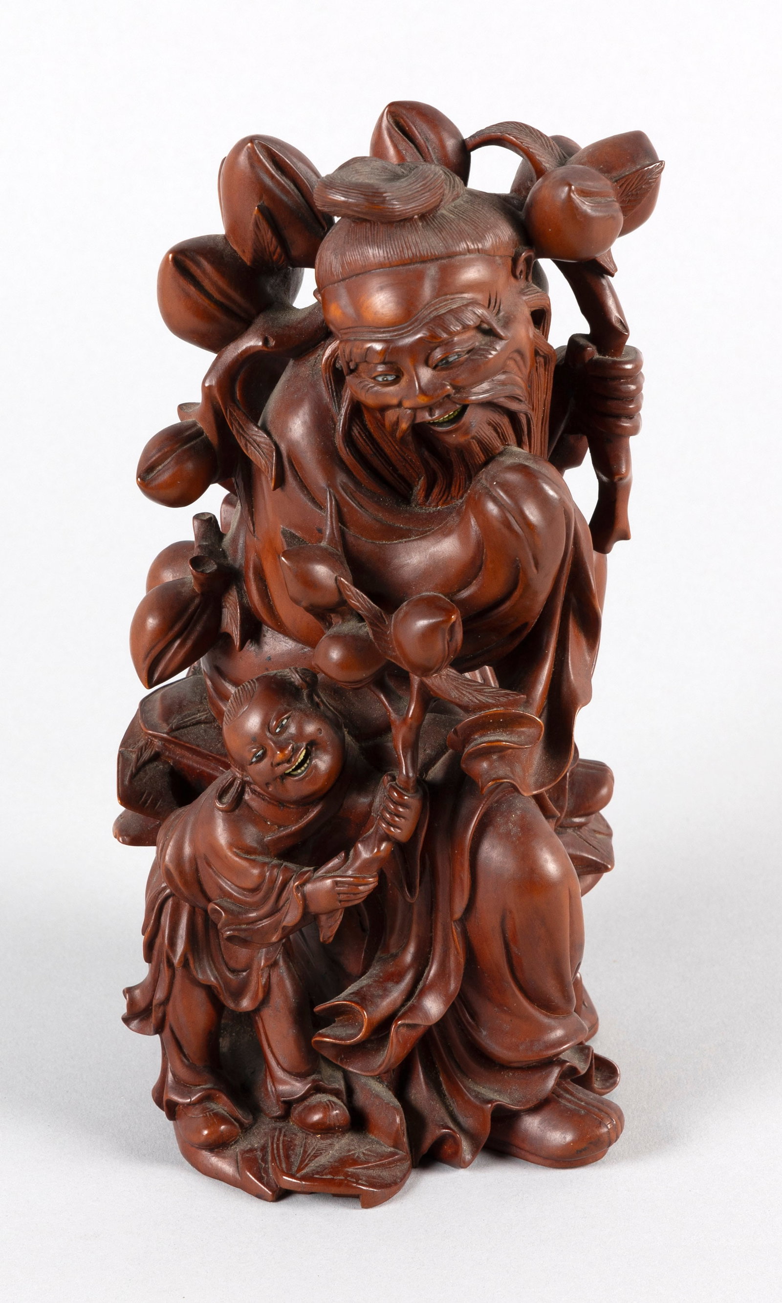 CHINESE CARVED BOXWOOD FIGURE GROUP OF SHOU LAO AND AN ATTENDANT Early 20th Century Height 9".: CHINESE CARVED BOXWOOD FIGURE GROUP OF SHOU LAO AND AN ATTENDANT Early 20th Century Both with inlaid eyes and teeth, and holding a peach tree staff. Height 9".