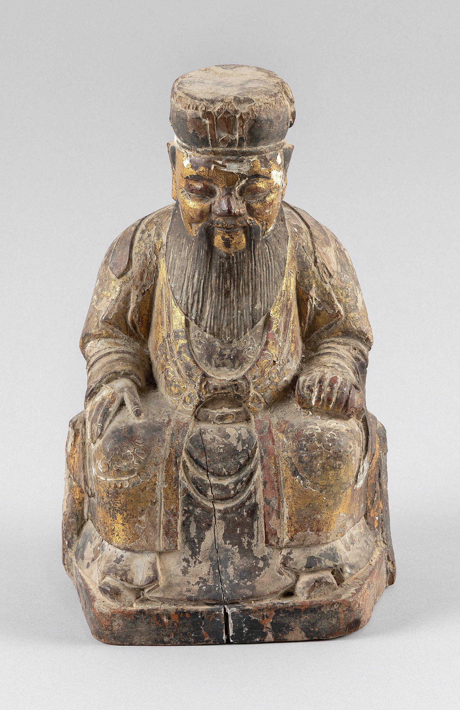 CHINESE CARVED GILTWOOD FIGURE OF A SEATED DEITY OR ANCESTRAL OFFICIAL Qing Dynasty Height 10".: CHINESE CARVED GILTWOOD FIGURE OF A SEATED DEITY OR ANCESTRAL OFFICIAL Qing Dynasty Possibly Tudigon or a high-ranking official. Traces of polychroming. Carved cavity on the obverse for a prayer scrol