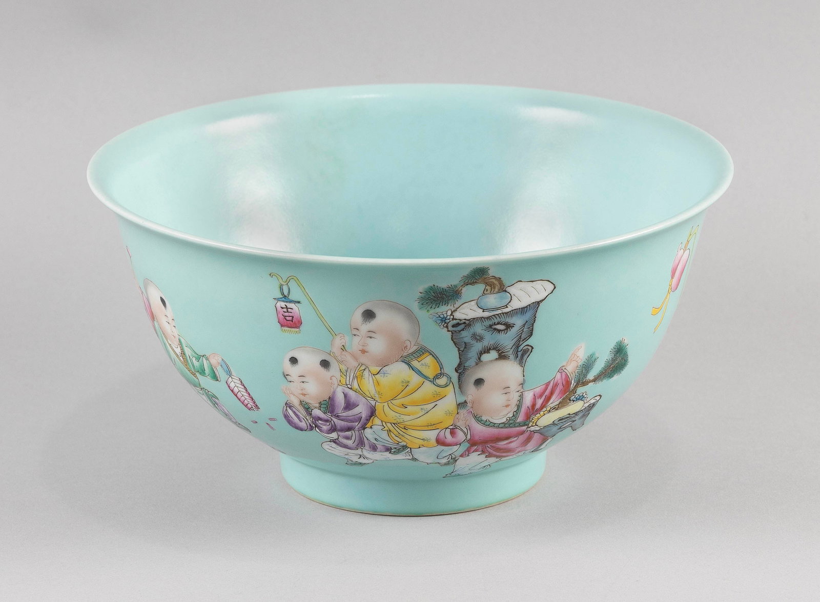 CHINESE FAMILLE ROSE PORCELAIN BOWL Early 20th Century Height 5.5".: CHINESE FAMILLE ROSE PORCELAIN BOWL Early 20th Century Decoration of seven children in a playful procession against a turquoise ground. Six-character Qianlong mark on base. Height 5.5".