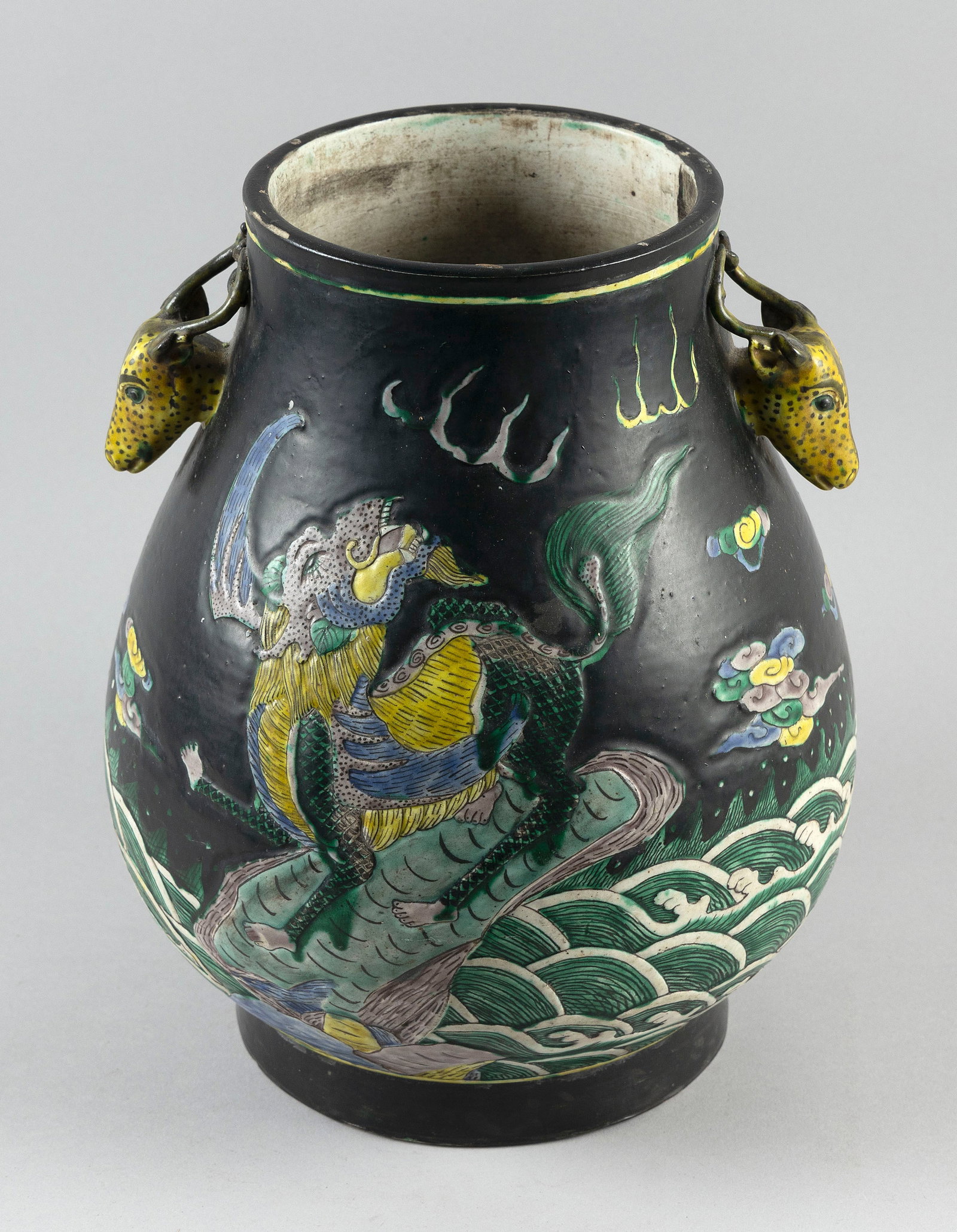 CHINESE FAMILLE VERTE PORCELAIN DEER HEAD VASE Possibly 18th Century Height 13". Maximum width 11".: CHINESE FAMILLE VERTE PORCELAIN DEER HEAD VASE Possibly 18th Century Raised decoration of mythological fu dogs on rockery surrounded by waves against a matte black ground filled with clouds and fiery 