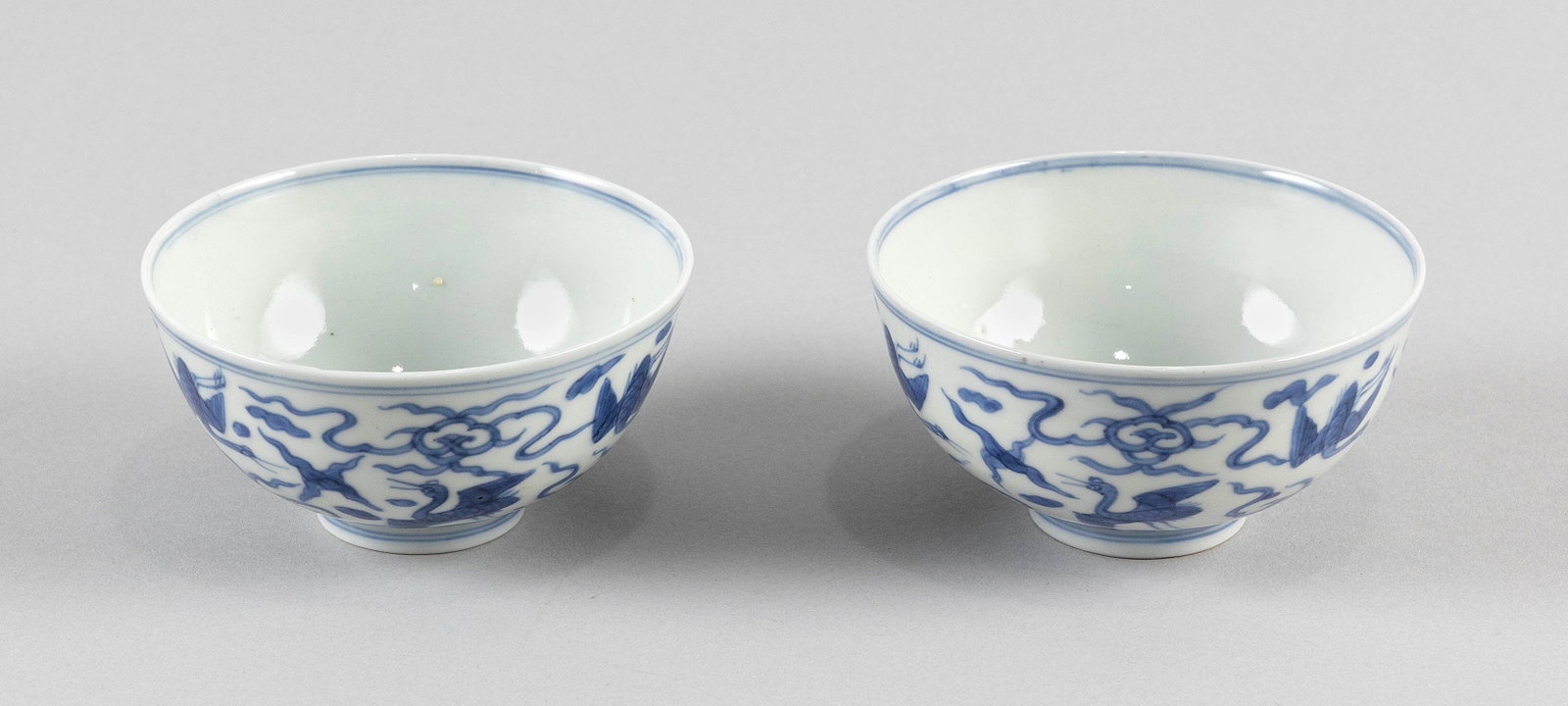 PAIR OF CHINESE BLUE AND WHITE PORCELAIN BOWLS Late 19th/Early 20th Century Heights 2.25". With: PAIR OF CHINESE BLUE AND WHITE PORCELAIN BOWLS Late 19th/Early 20th Century Decoration of flying cranes amongst clouds. Marked on bases. Heights 2.25". With fitted box.