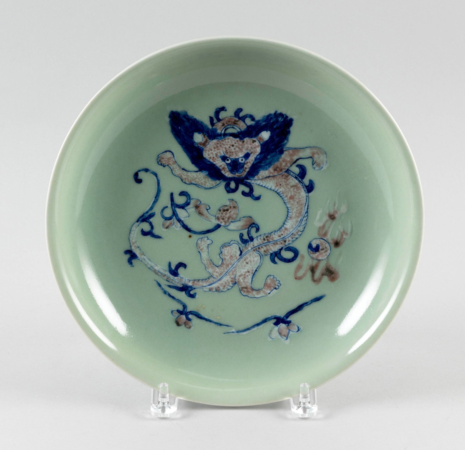 CHINESE IRON RED, BLUE AND WHITE ON CELADON PORCELAIN SHALLOW BOWL First Half 20th Century Diameter: CHINESE IRON RED, BLUE AND WHITE ON CELADON PORCELAIN SHALLOW BOWL First Half 20th Century Decoration of a stylized dragon chasing a fiery pearl. Six-character Qianlong mark on base. Diameter 11". Wit