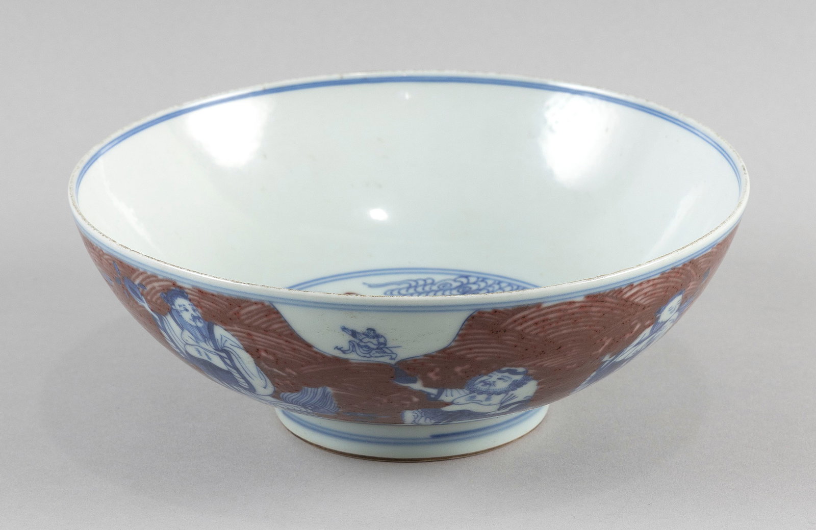 CHINESE UNDERGLAZE BLUE AND IRON RED PORCELAIN BOWL Late 19th/Early 20th Century Height 3". Diameter: CHINESE UNDERGLAZE BLUE AND IRON RED PORCELAIN BOWL Late 19th/Early 20th Century Decoration of the Eight Immortals, a deity rondel and deer. Six-character Kangxi mark on base. Height 3". Diameter 8.5"