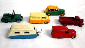 6 Dinky Toys Vintage Trucks: Lot of 6 vintage Dinky Toys trucks made in England c 1950s. Includes Red Austin Nestle's delivery van, Austin flatbed truck (1 headlamp missing), two-tone Austin Taxi, Bedford Dinky Toys truck, Jeep (